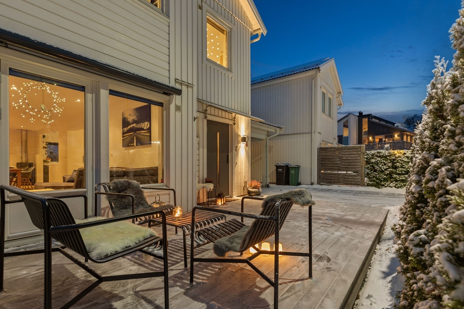 Romslig terrasse på forsiden av boligen, med kveldssol og utsikt mot Glomma. Galleribilde