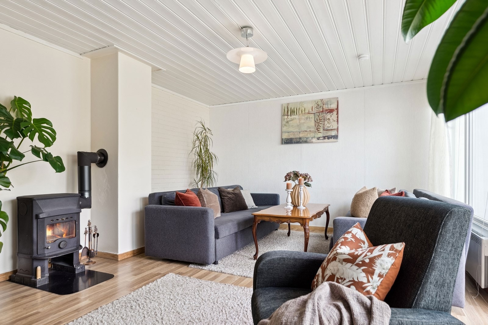 Stuen varmes opp via panelovn på vegg, og vedovn i rommet sørger for god temperatur og knitrende hygge. Galleribilde