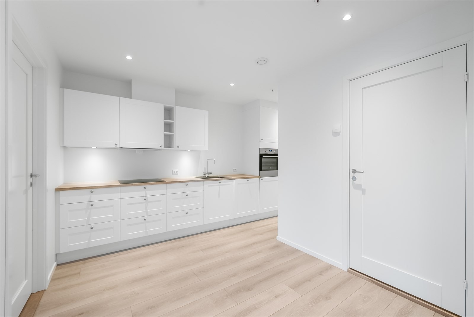 Pent Strai kjøkken i lys moderne profilering med alle hvitevarer integrert. Galleribilde