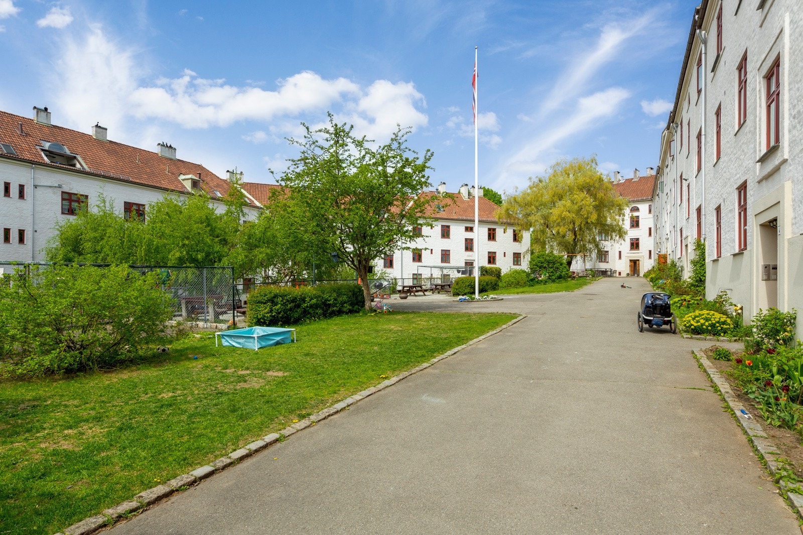 - Felles gårdsrom pent opparbeidet med gressplener, flaggstang, trær og variert beplantning - Galleribilde