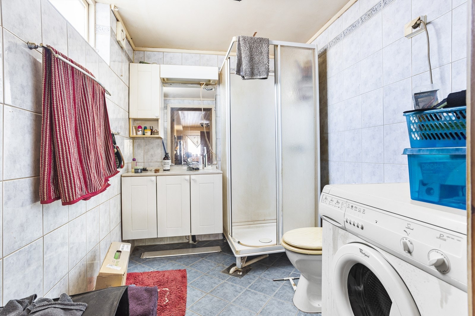 Bad i underetasjen med flislagte overflater. Innredet med servant i servantskap, toalett, dusjkabinett og opplegg for vaskemaskin. Galleribilde