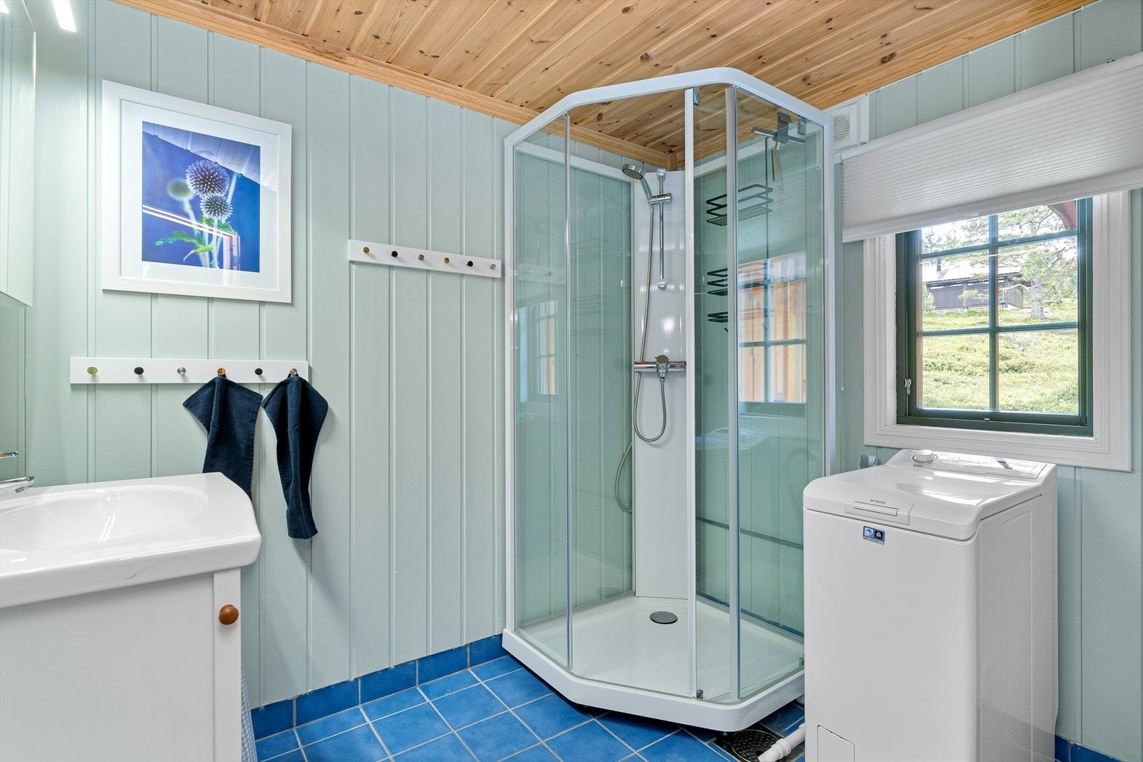 Badet er innredet med servant, dusjkabinett og opplegg for vaskmaskin. Galleribilde