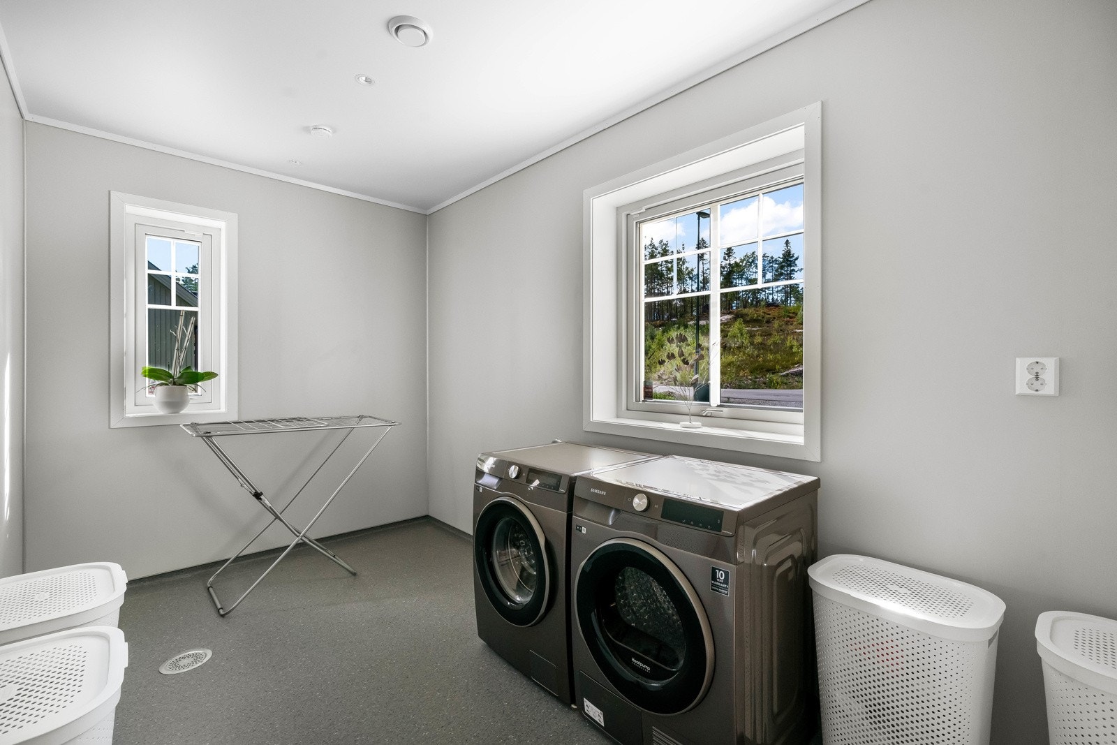 I 1.etasje ligger et stort, praktisk vaskerom med belegg på gulv, baderomsplater på vegg og malte flater i himling. Belysning via downlights. Rommet er utstyrt med opplegg for vaskemaskin og tørketrommel. God plass til vaskeromsinnredning etc. Galleribilde