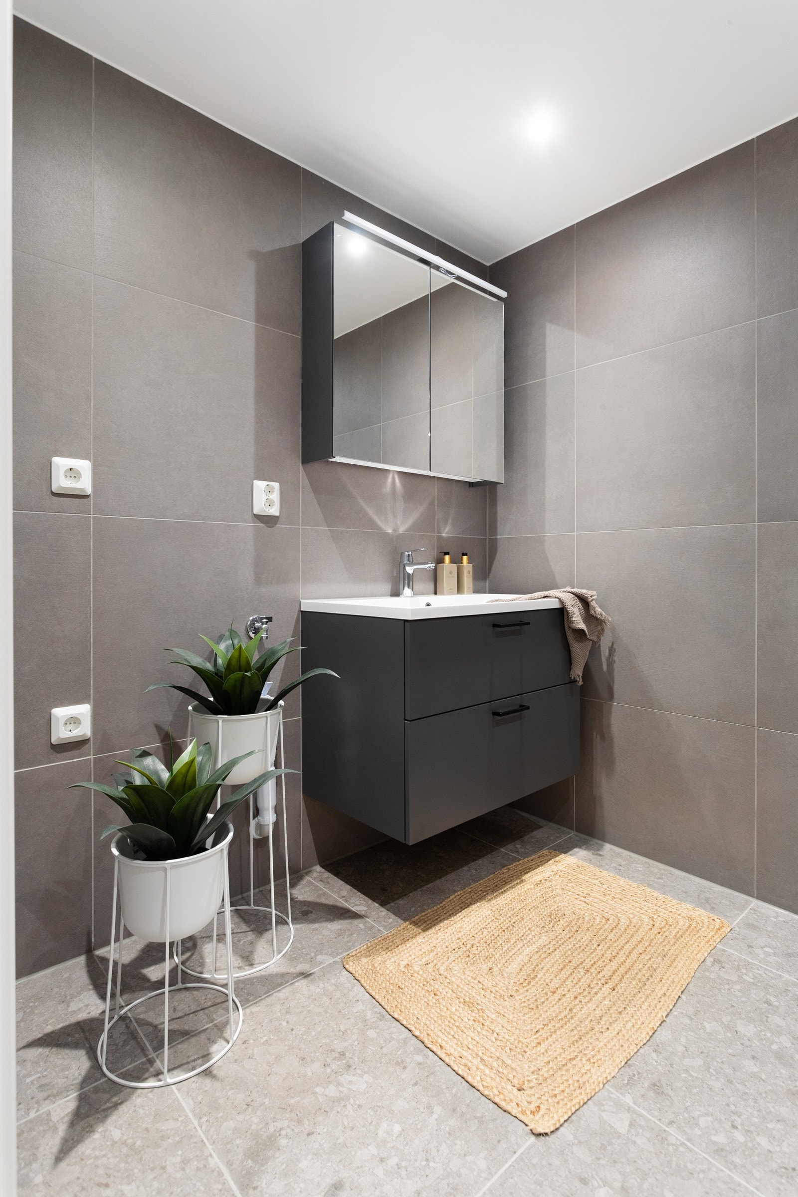 Moderne baderomsinnredning fra Sigdal med skuffer og heldekkende servant, speilskap med belysning over. Plass og opplegg for vaskemaskin og tørketrommel over om ønskelig. Galleribilde