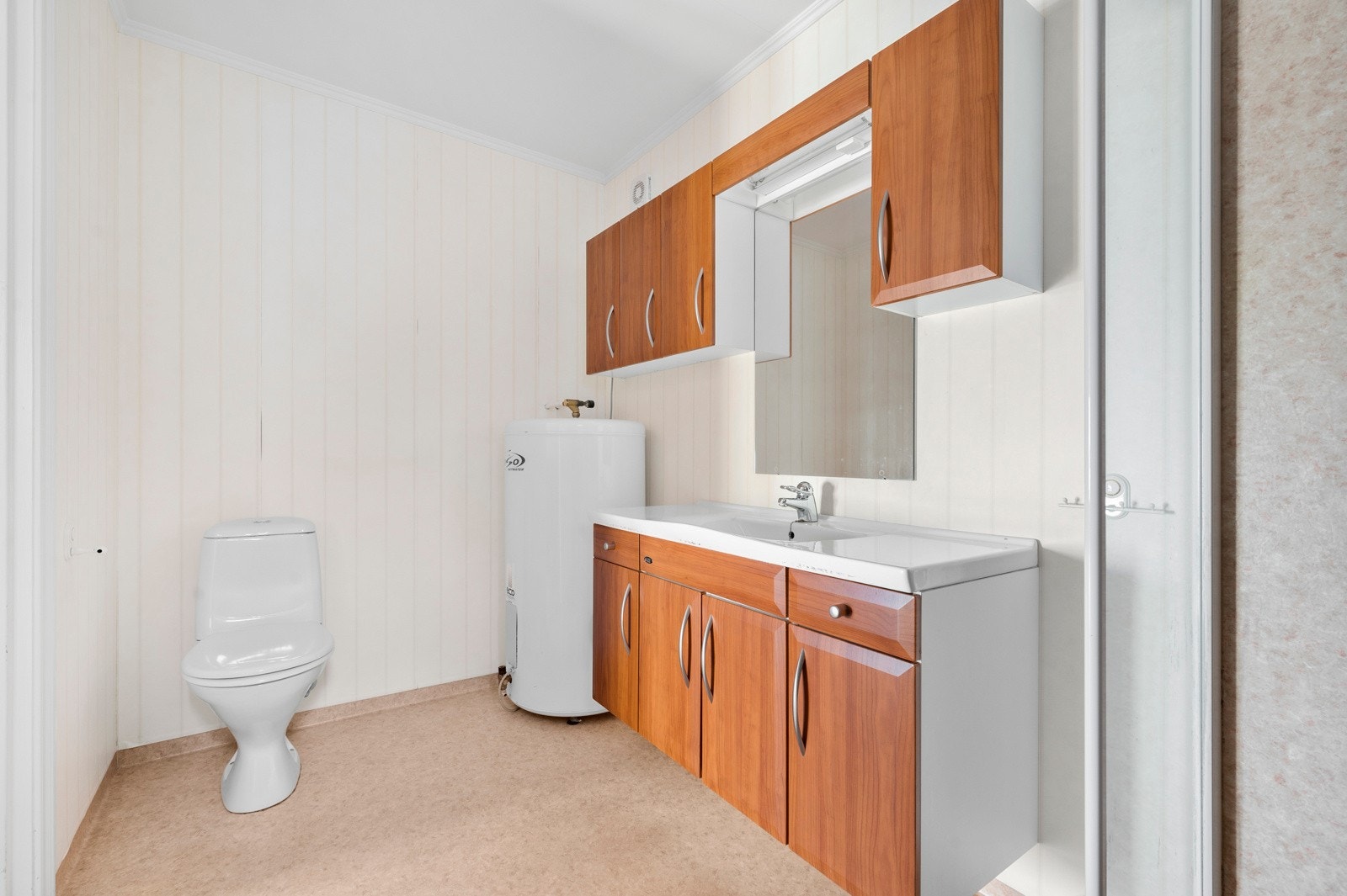 Badet har stor innredning og praktisk belegg på gulv, og dusj. Det er også her varmtvannsberederen står. Galleribilde