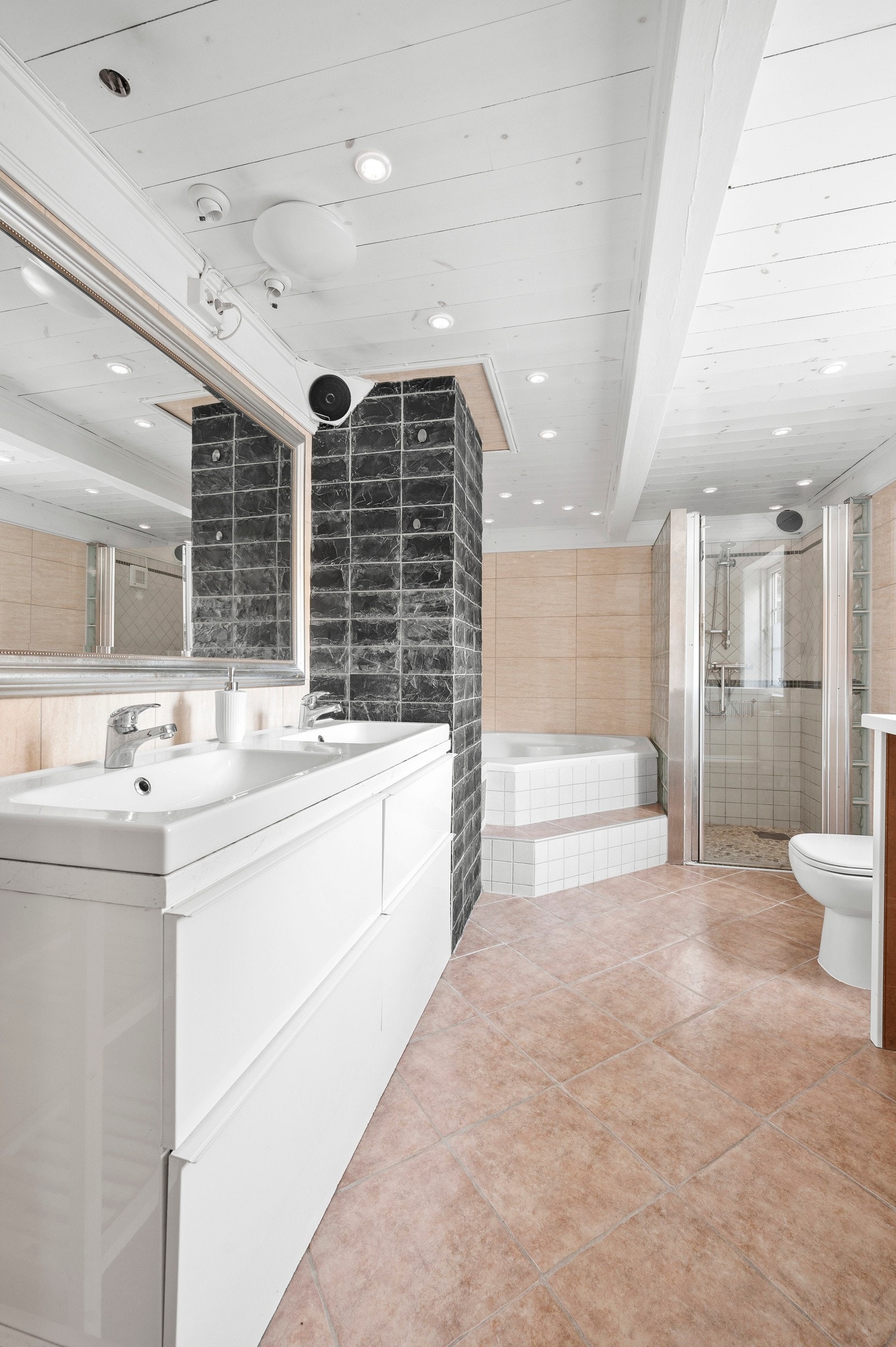 Badet er langstrekt og har både dusj og badekar. Det er fliser med gulvvarme og dobbel servantinnredning. Galleribilde
