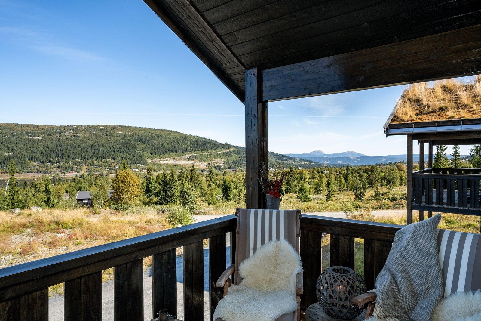Direkte fra stuen er det utgang til den overbygde balkongen, luftig plassert opp fra bakkeplan, og med fin utsikt mot områdene rundt. Galleribilde