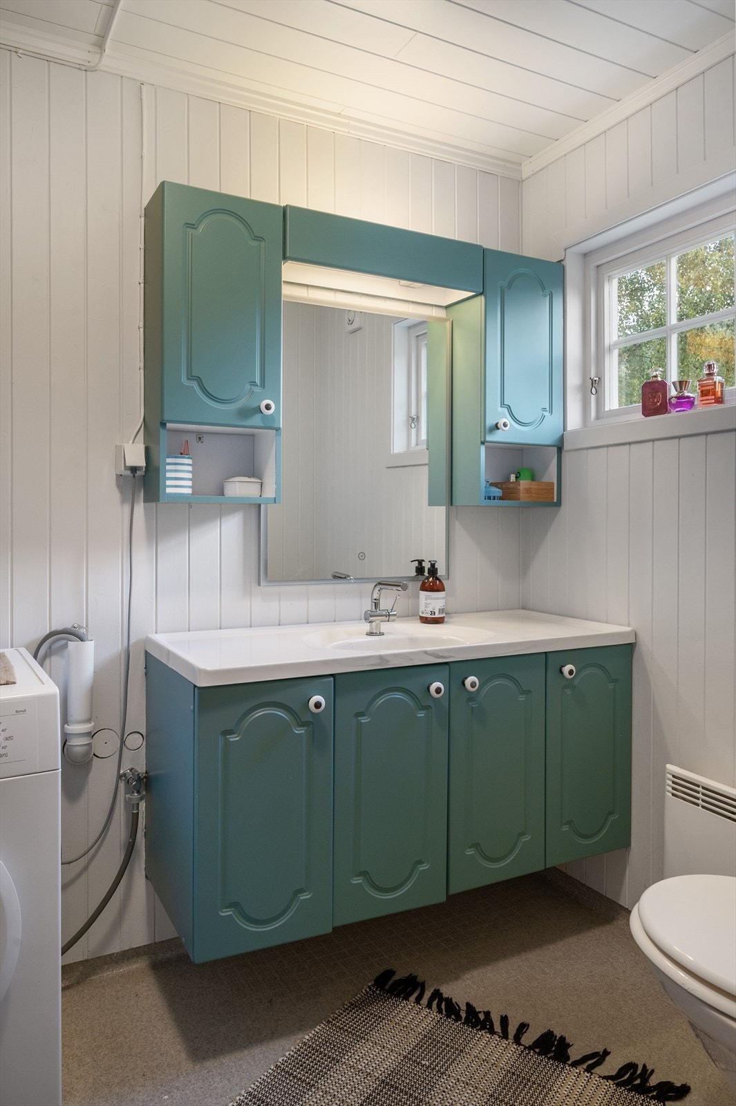 Badet er utstyrt med WC, dusjkabinett, servant med skap samt opplegg for vaskemaskin. Galleribilde