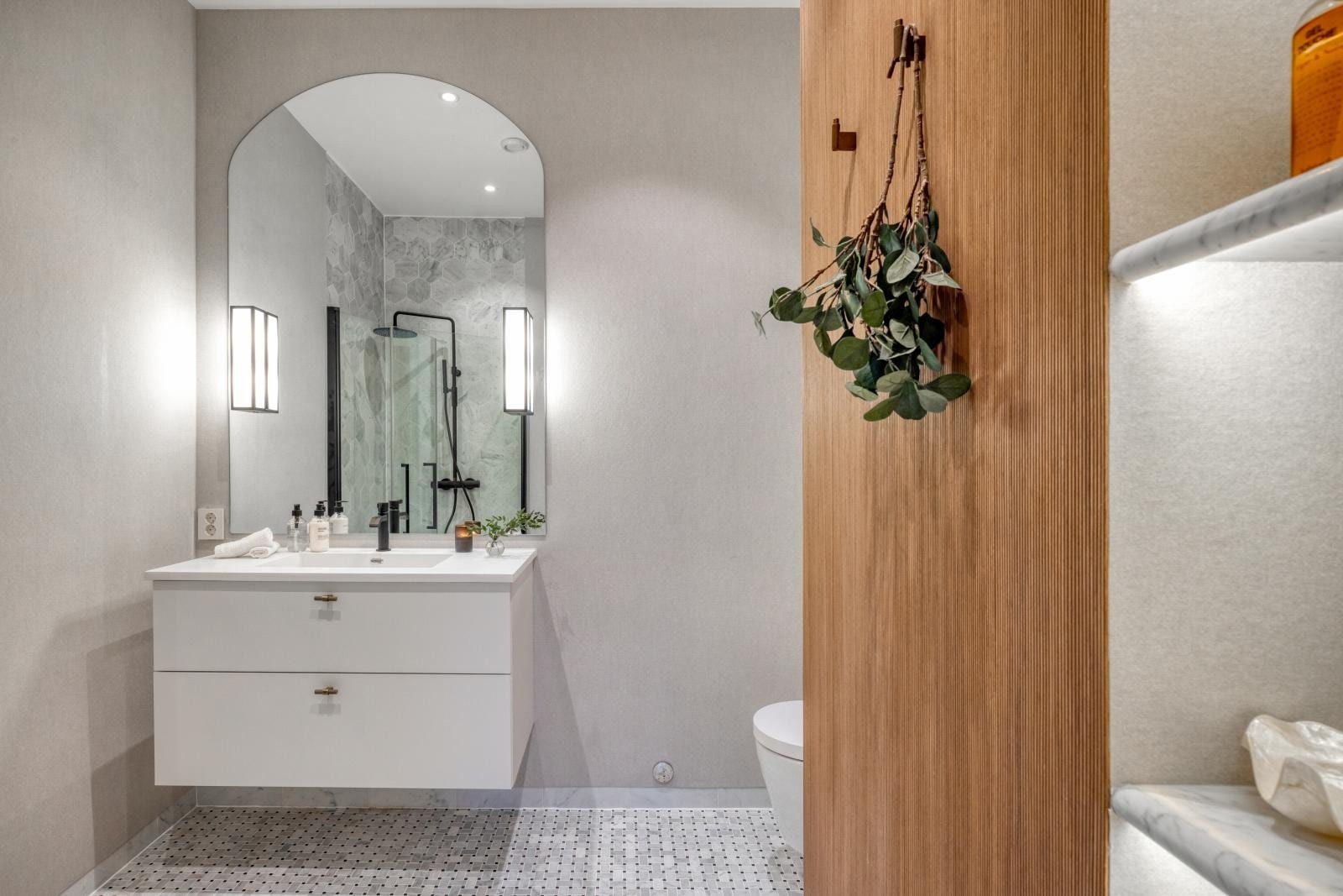 Baderomsinnredning fra HTH med håndtak fra Beslagdesign og stort skreddersydd speil med belysning. Galleribilde