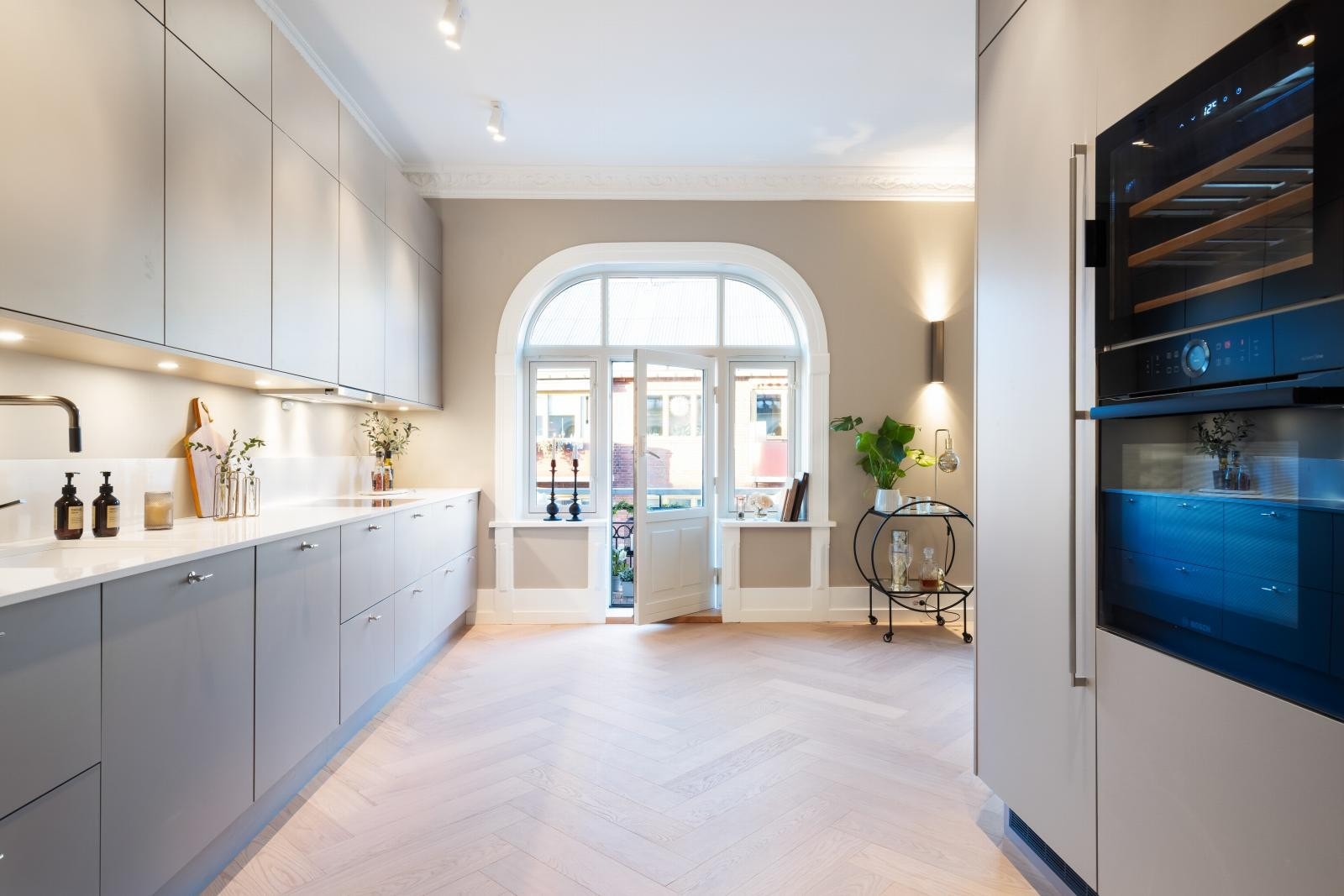 Pent kvalitetskjøkken fra HTH 2023 med slette fronter og kompositt benkeplate fra Granitop med backsplash. Galleribilde