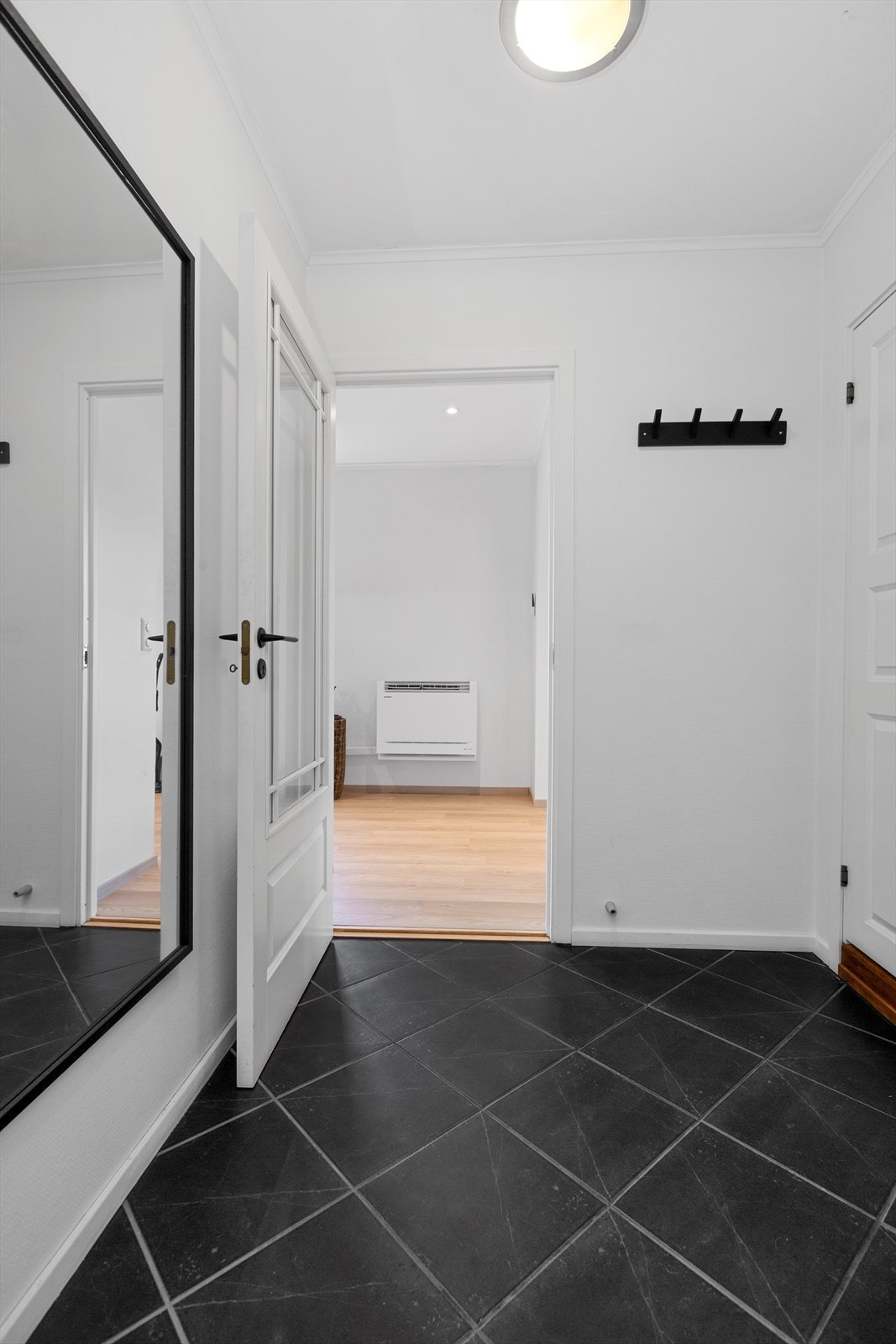 Flislagt entre med god plass til omkledning og oppbevaring av yttertøy Galleribilde