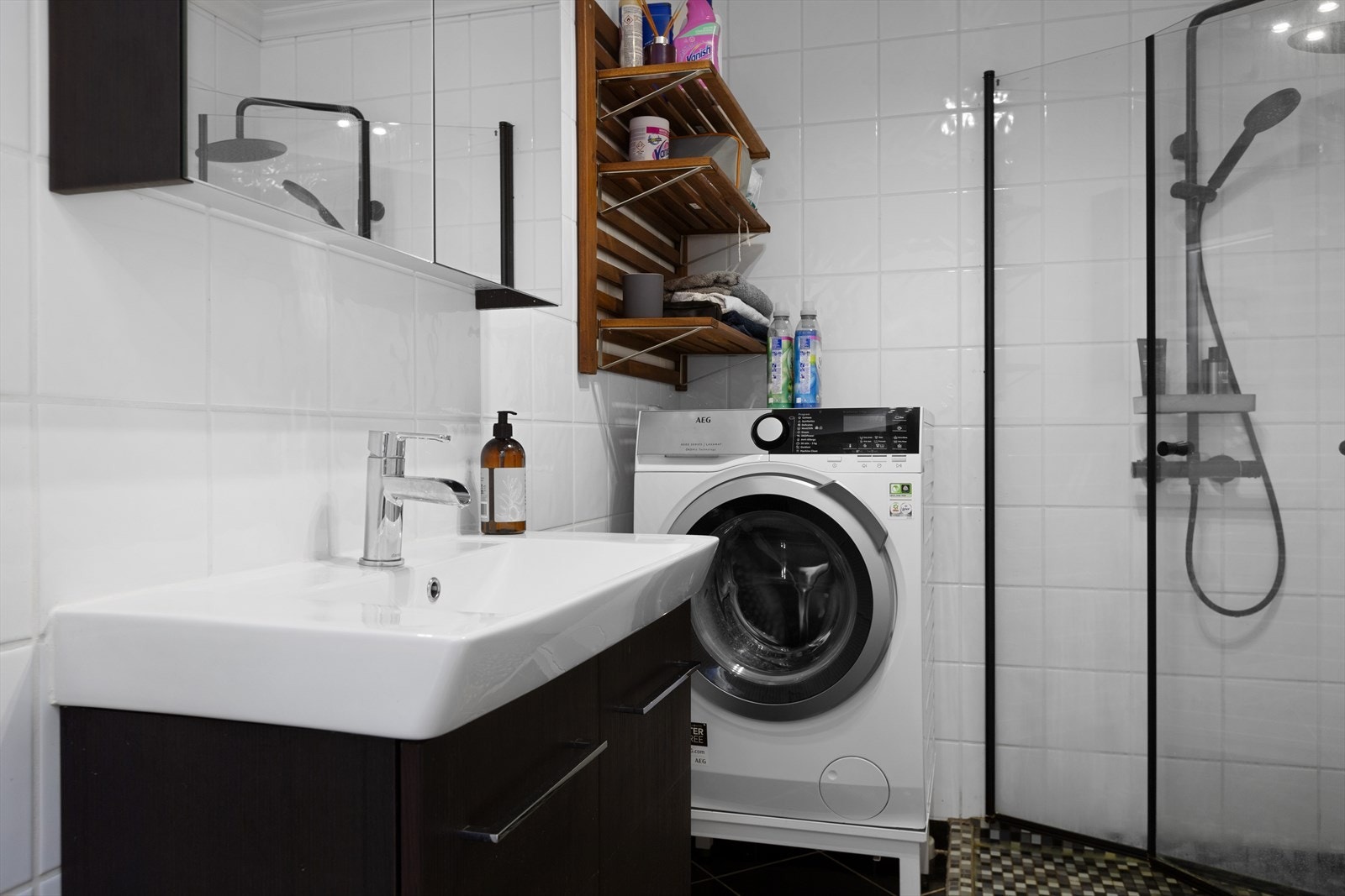 Badet er innredet med dusjhjørne med innfellbare dører, WC og servant med tilhørende skap Galleribilde