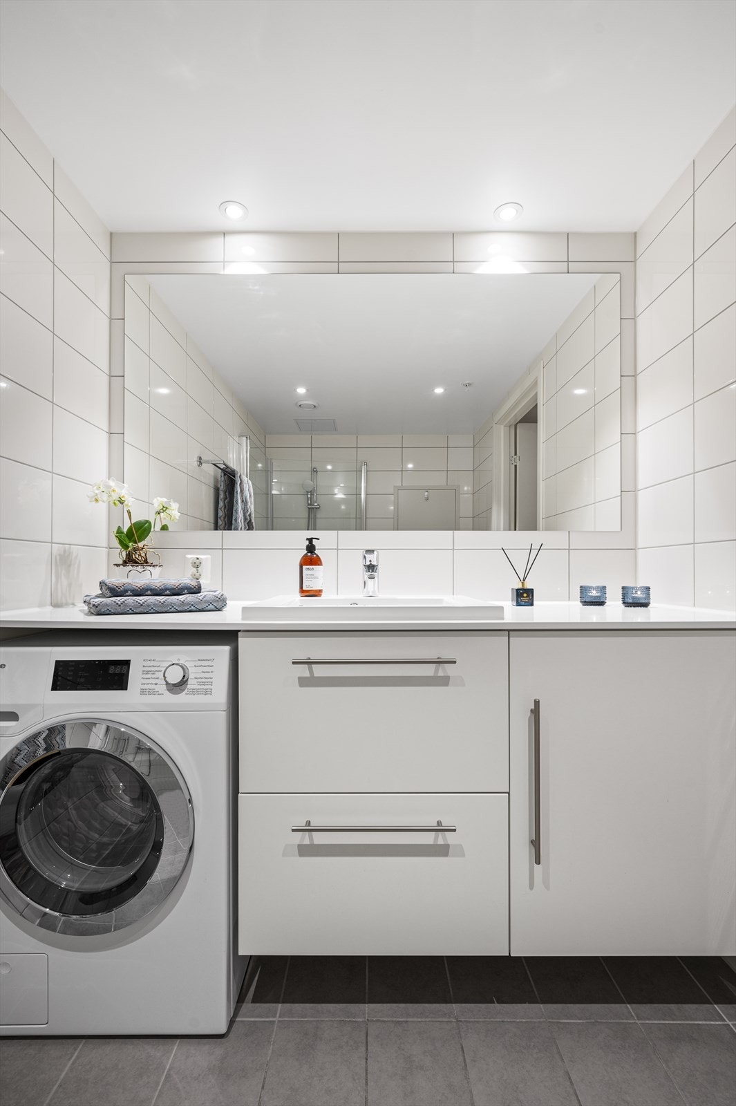Badet er også utstyrt med en moderne servant og skuffeinnredning og opplegg for vaskemaskin Galleribilde