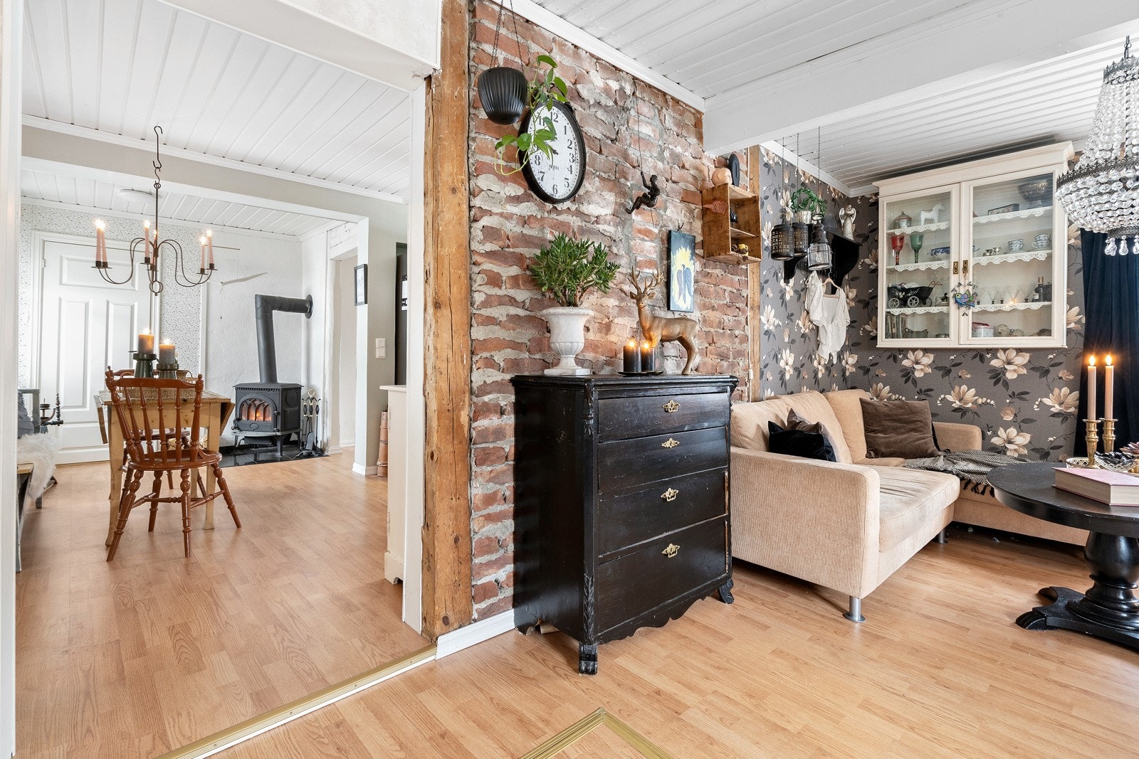 I stuen er det valgt tapet og eksponert teglstein. Delvis åpen løsning mellom rommene. Galleribilde