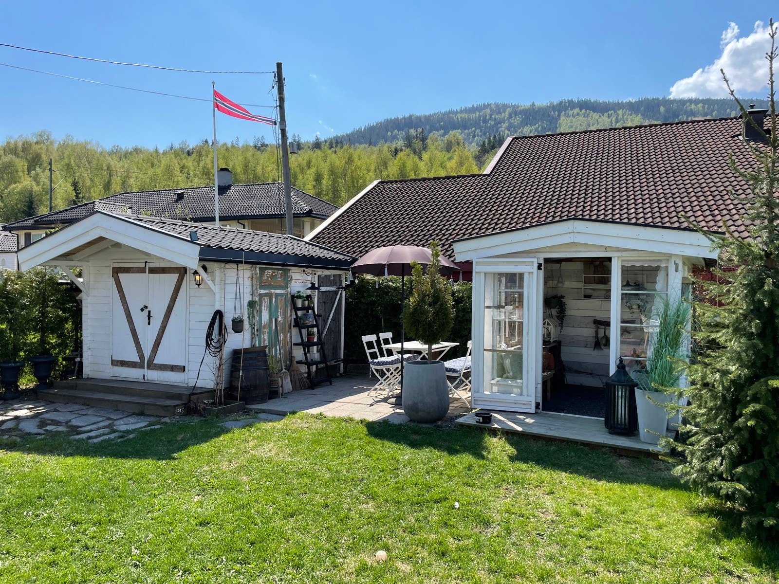 Bod og vinterhage/drivhus med grillplass mellom seg. Galleribilde