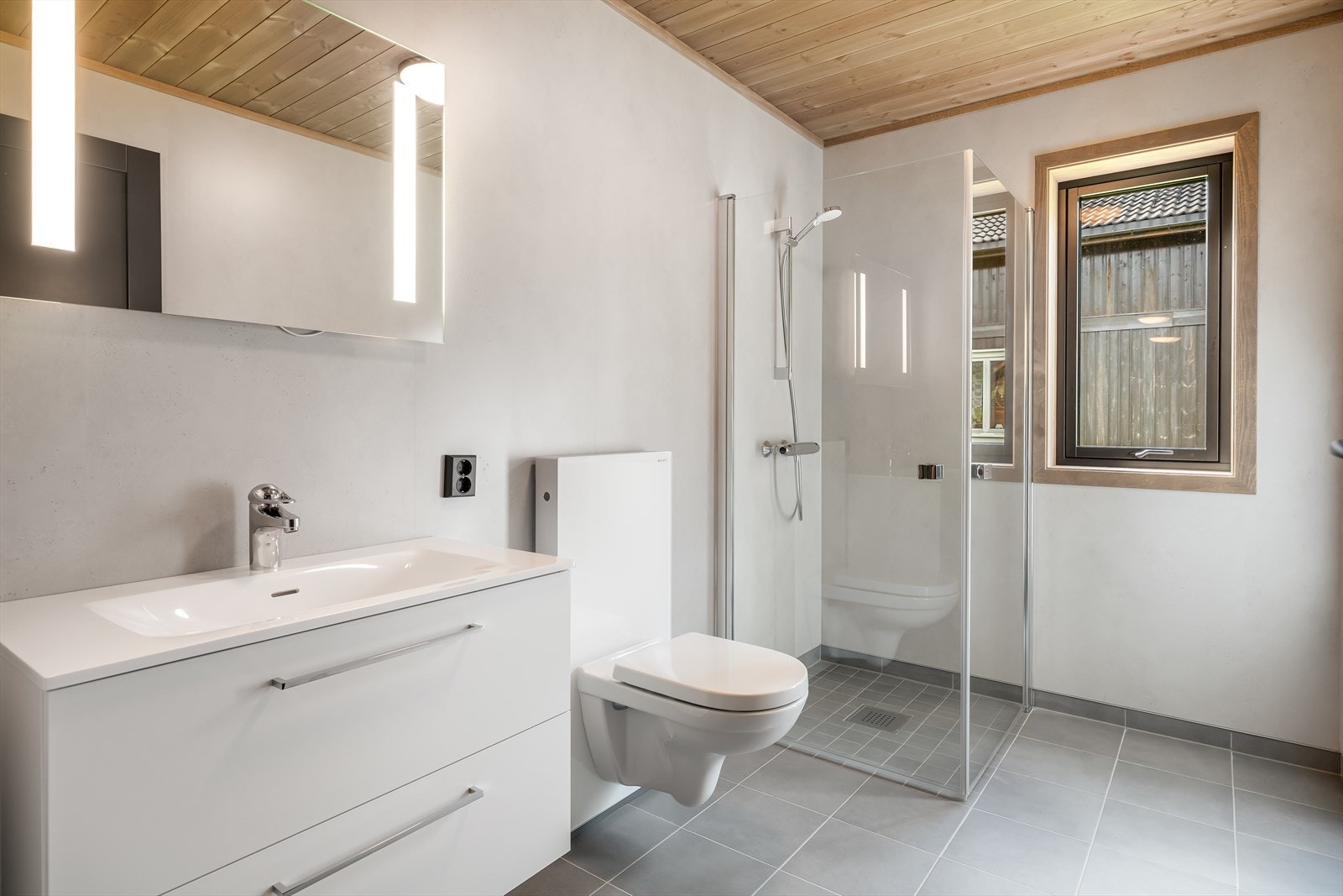 Det er fliser på gulv, baderomsplater av type Fibo Soft Cement på vegger og beiset trepanel i himlinger. Galleribilde