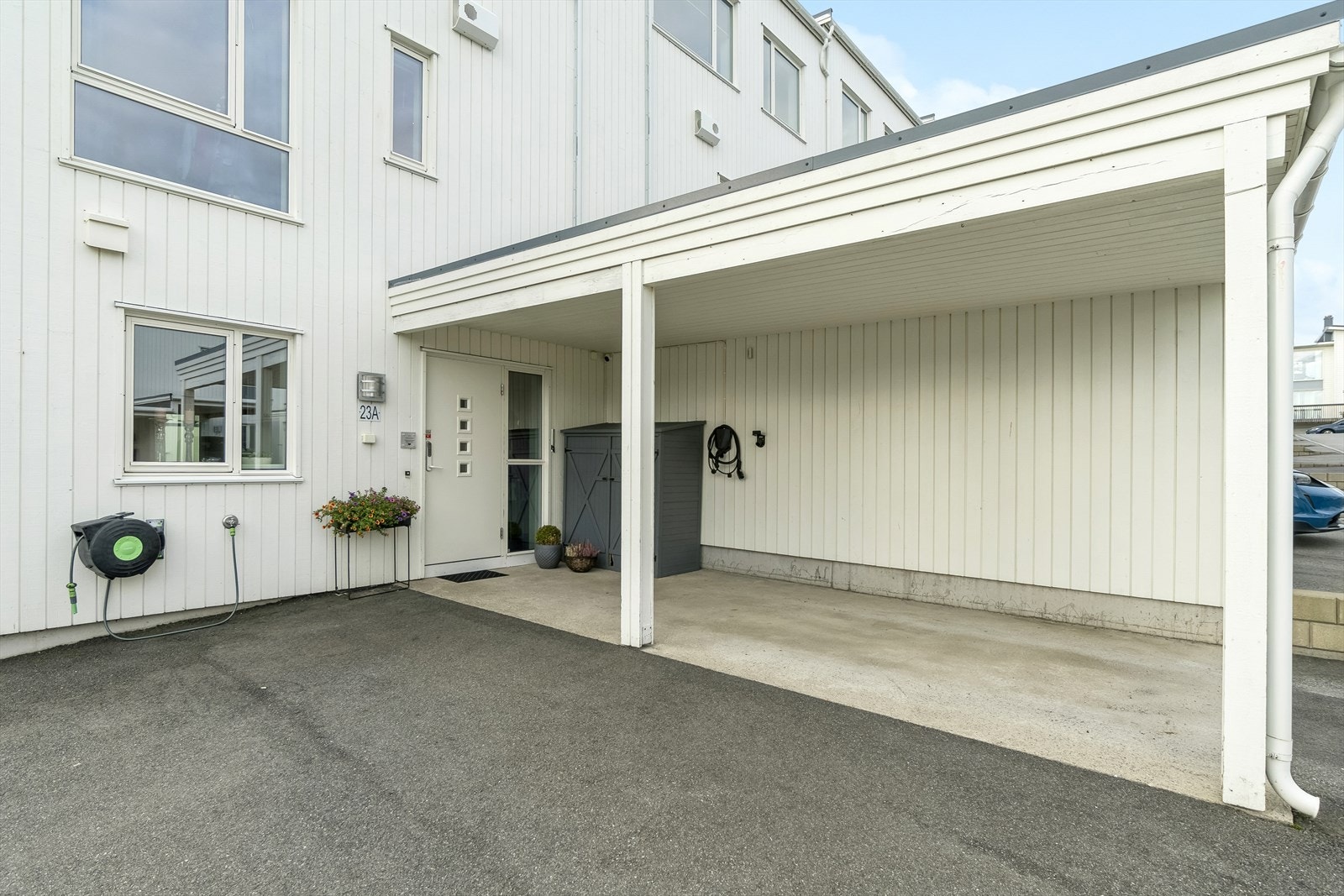 Asfaltert inngangsparti med carport. Ladepunkt for El/Hybridbil medfølger. Galleribilde