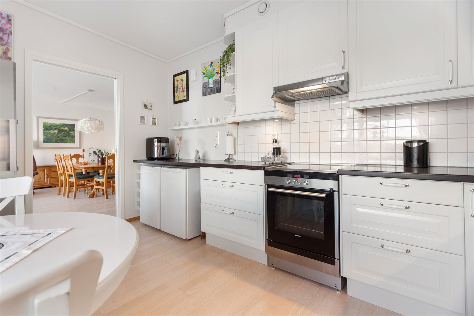 Kjøkkenet er ellers innredet med laminat benkeplate, fliser på vegg over benkeplate, kjøleskap, fryseskap, oppvaskmaskin og komfyr. Galleribilde