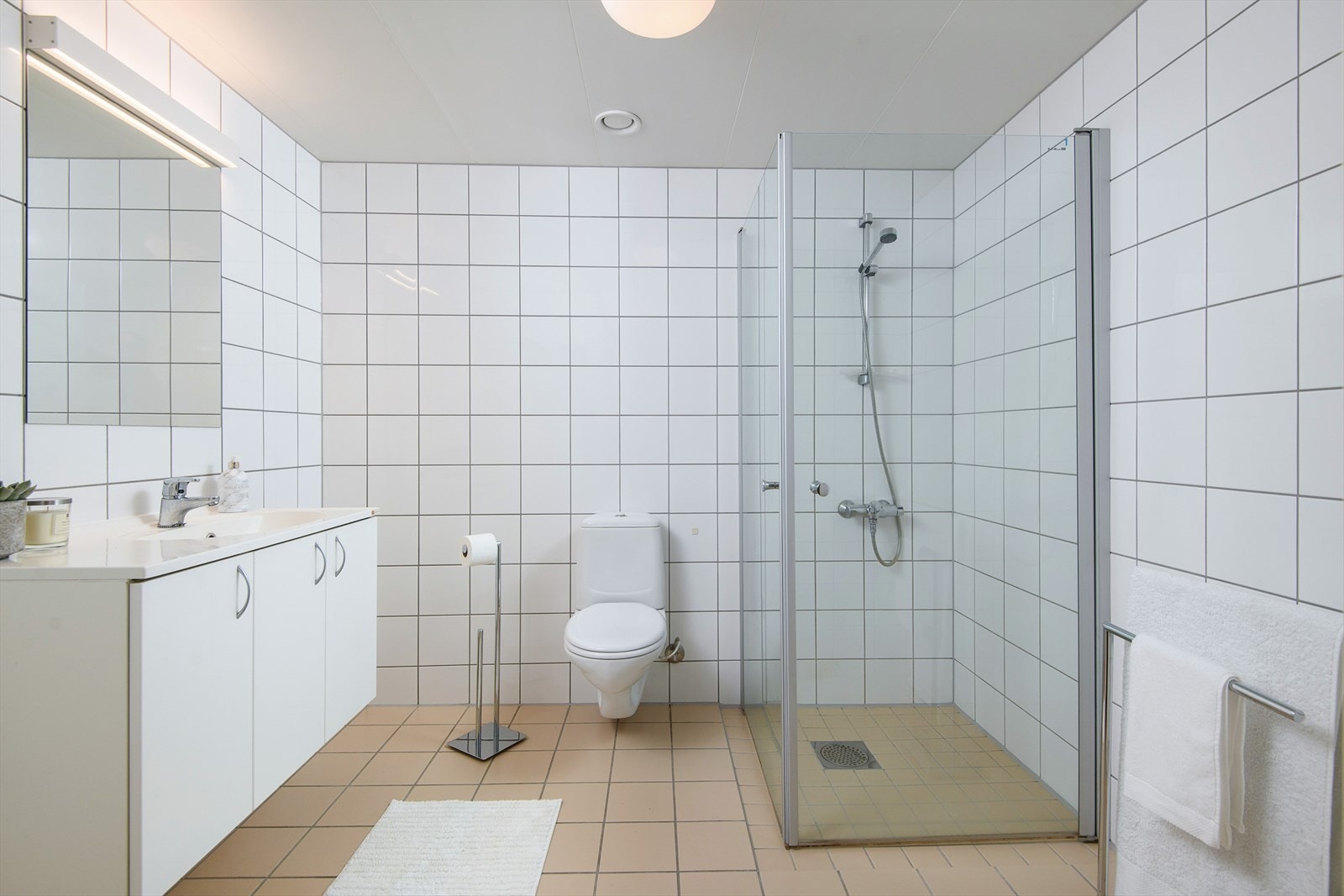 Stilrent og funksjonelt bad/wc med servantinnredning, dusjhjørne og wc. Galleribilde