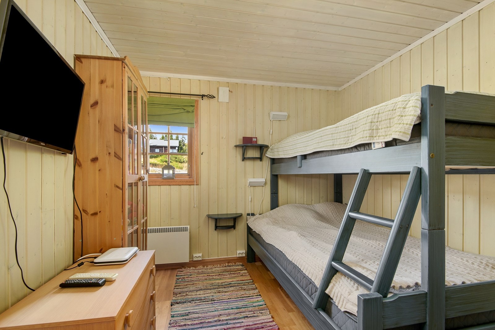 Soverom innredet med familiekøye. Det er også plass til møbler for oppbevaring. Vegger og tak er malt i lyse fargetoner. Galleribilde