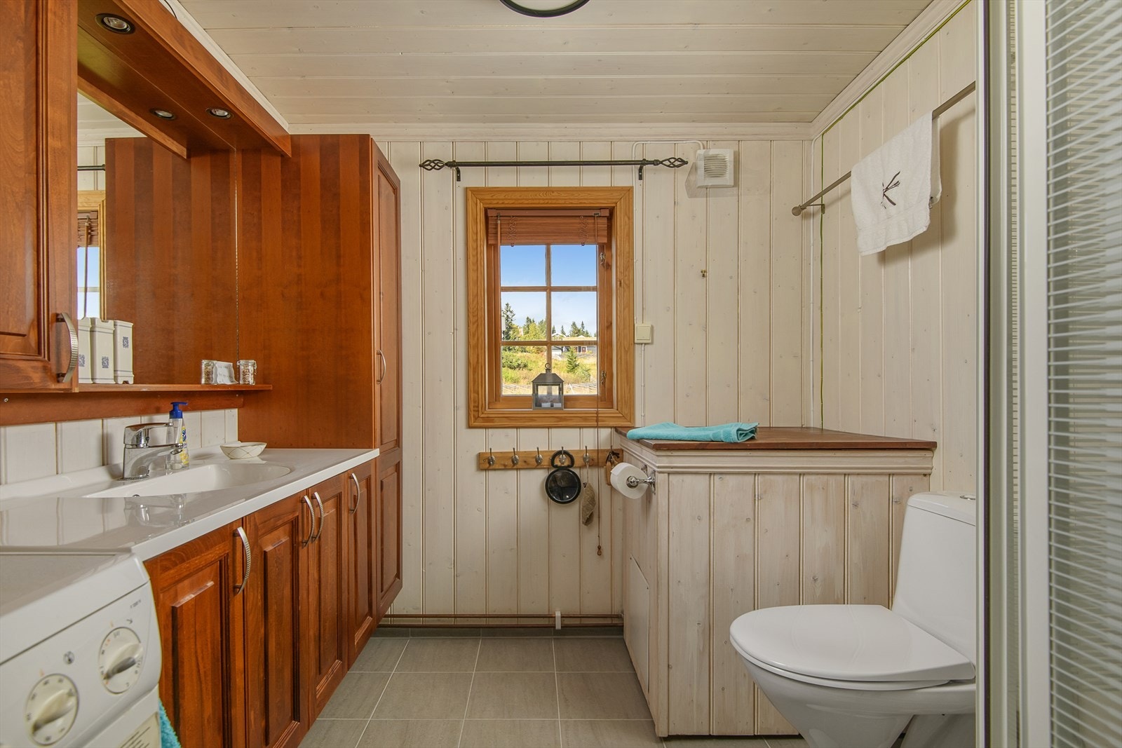 Funksjonelt bad/wc med flilsagt gulv som har varmekalber. Opplegg for vaskemaskin. Galleribilde