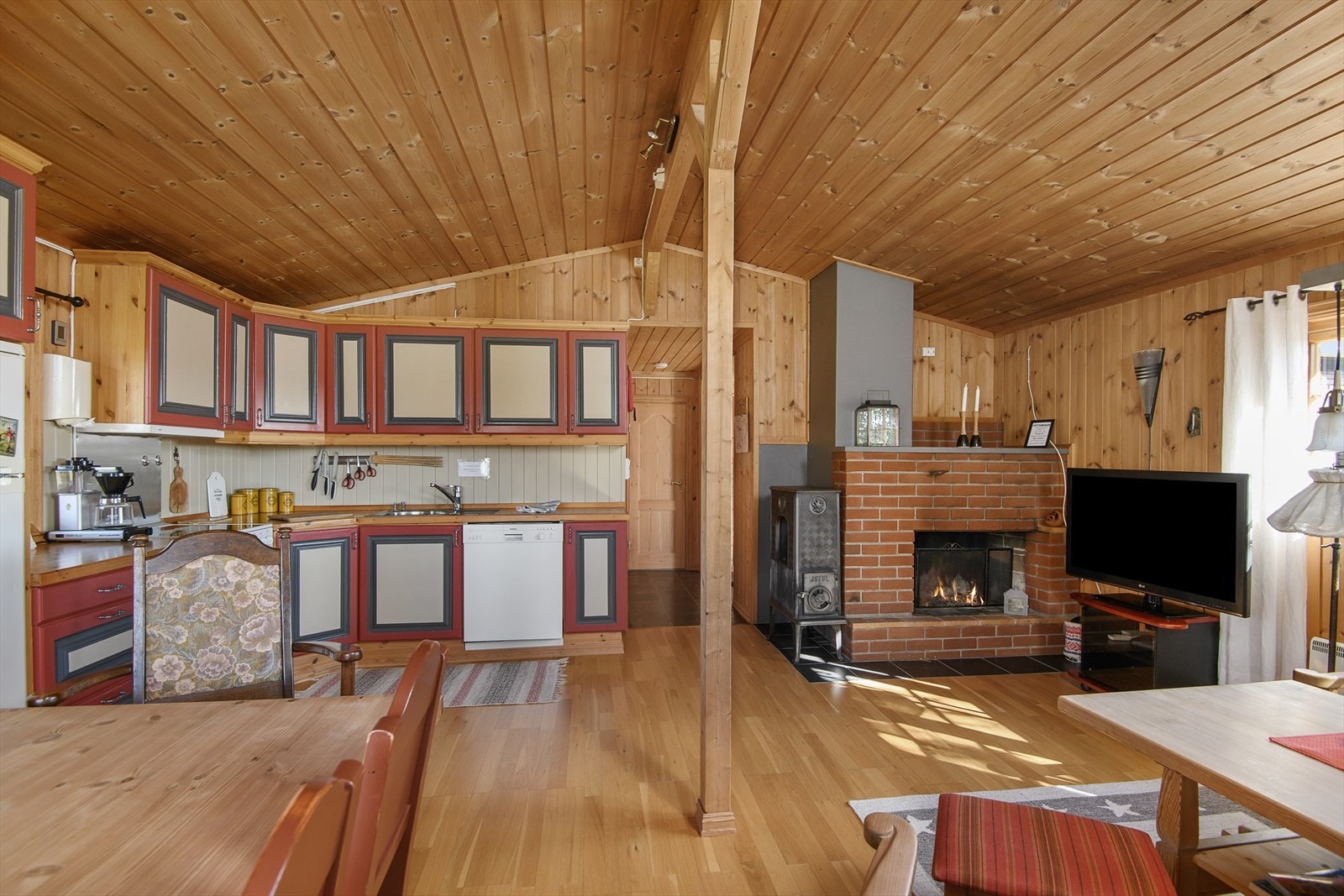 Hytta har en åpen løsning mellom kjøkken og stue, noe som gir et hyggelig og sosialt oppholdsrom. Galleribilde