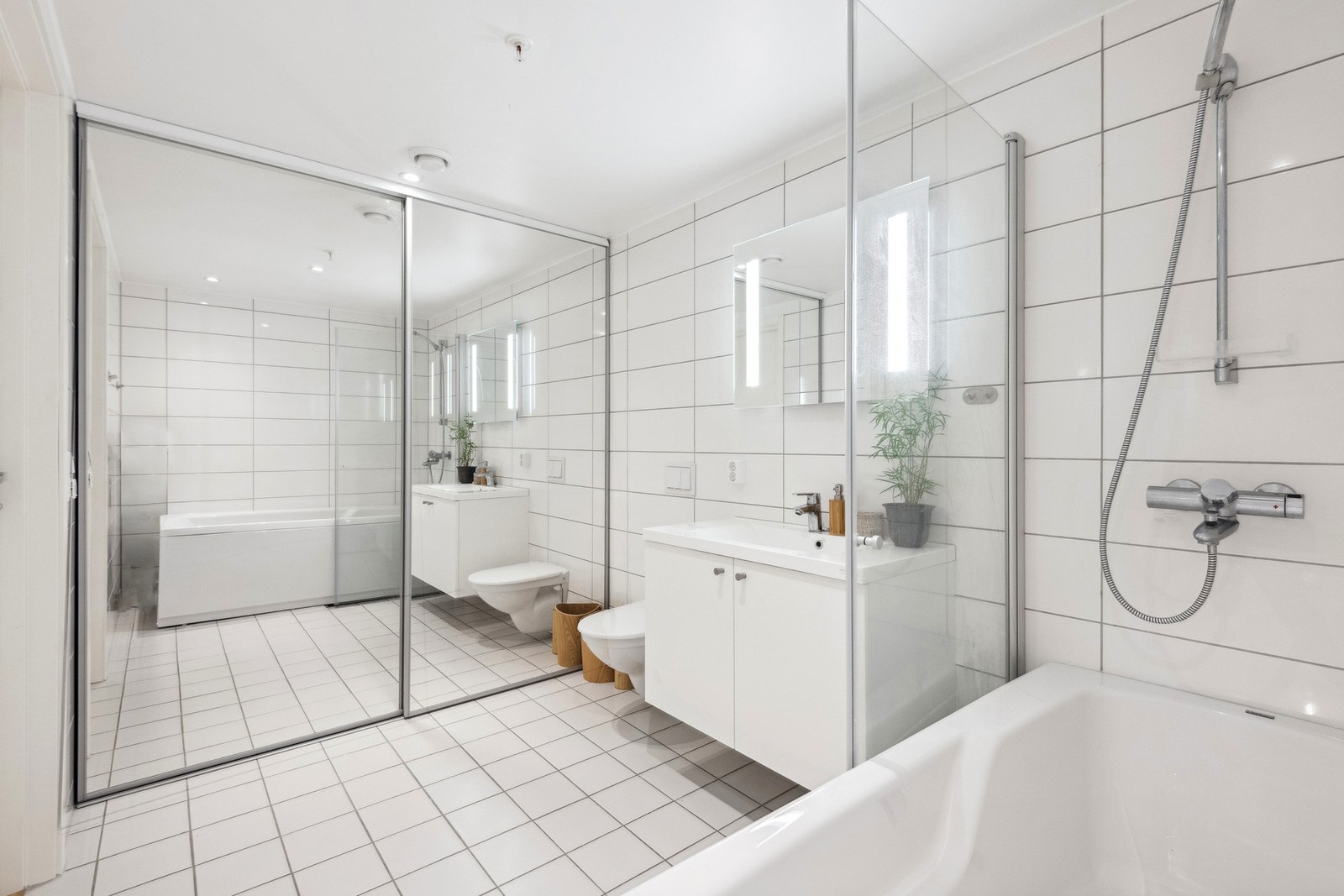 Bad 1 i boligen har direkte inngang fra hovedsoverommet med flislagt gulv, vegghengt WC og varmekabler i gulv. Man har også en svært praktisk skyvedørsgarderobe med mye oppbevaring. Galleribilde