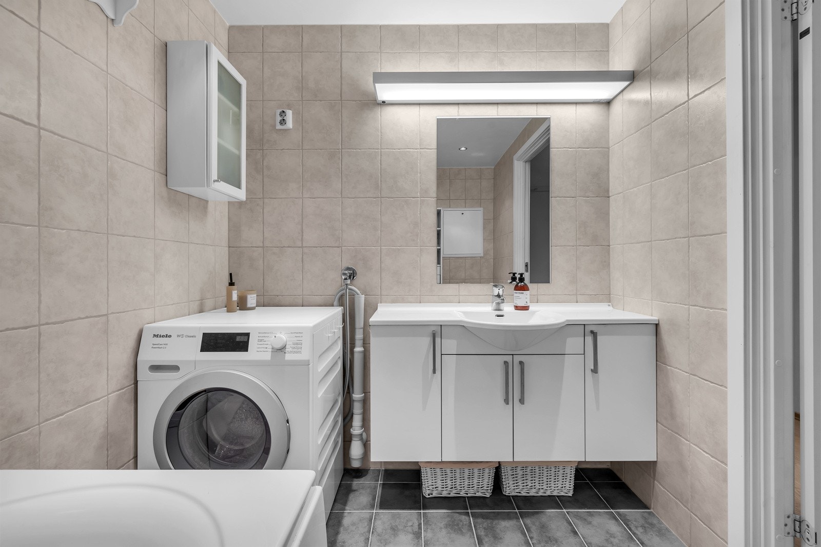 Badet som er praktisk og pent med fliser på gulv og vegger Galleribilde