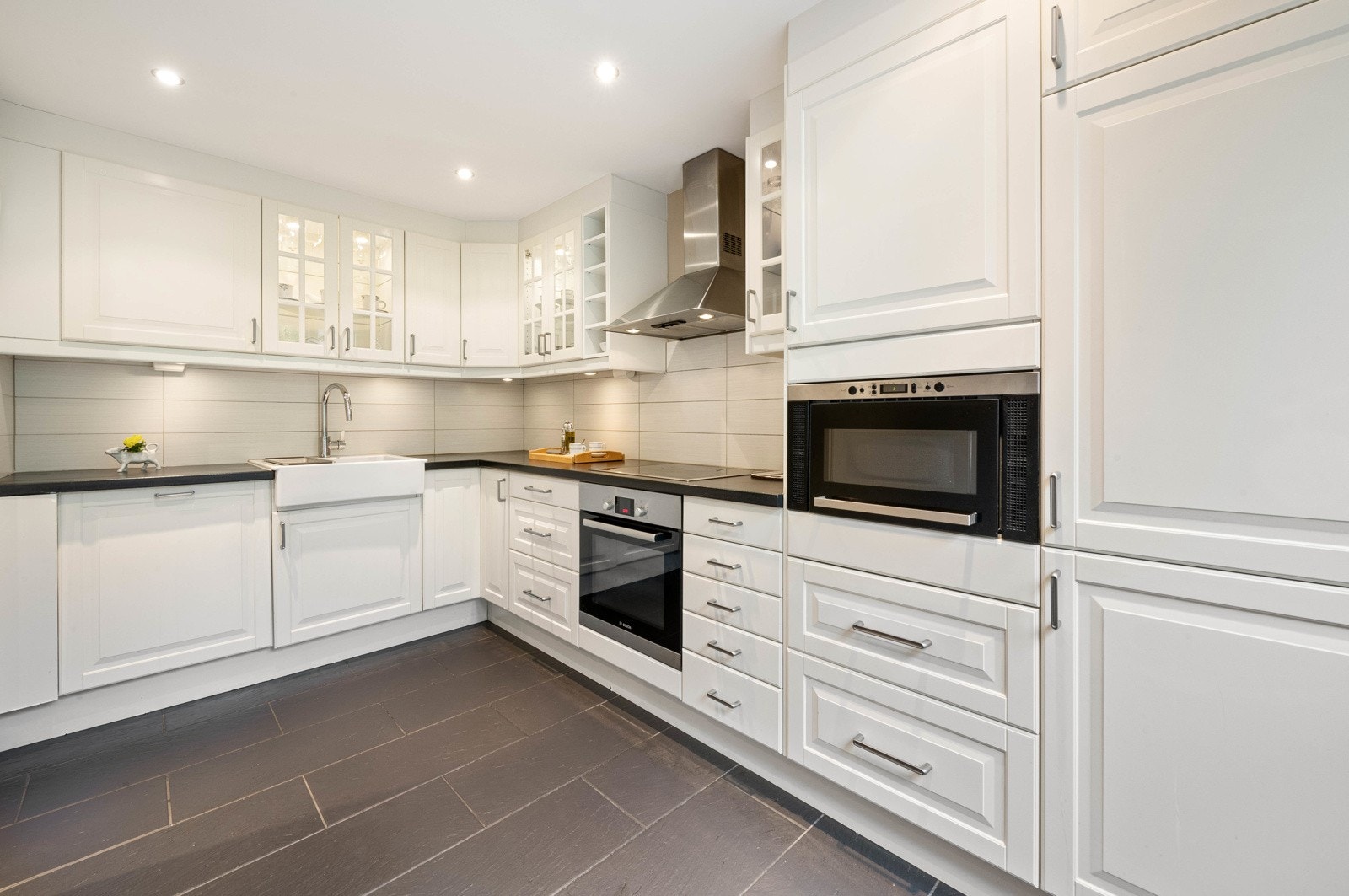 IKEA kjøkken med integrerte hvitevarer. Downlights både i taket, vitrineskapene og under overskapene. Nyere komfyr, koketopp og blandebatteri. Galleribilde