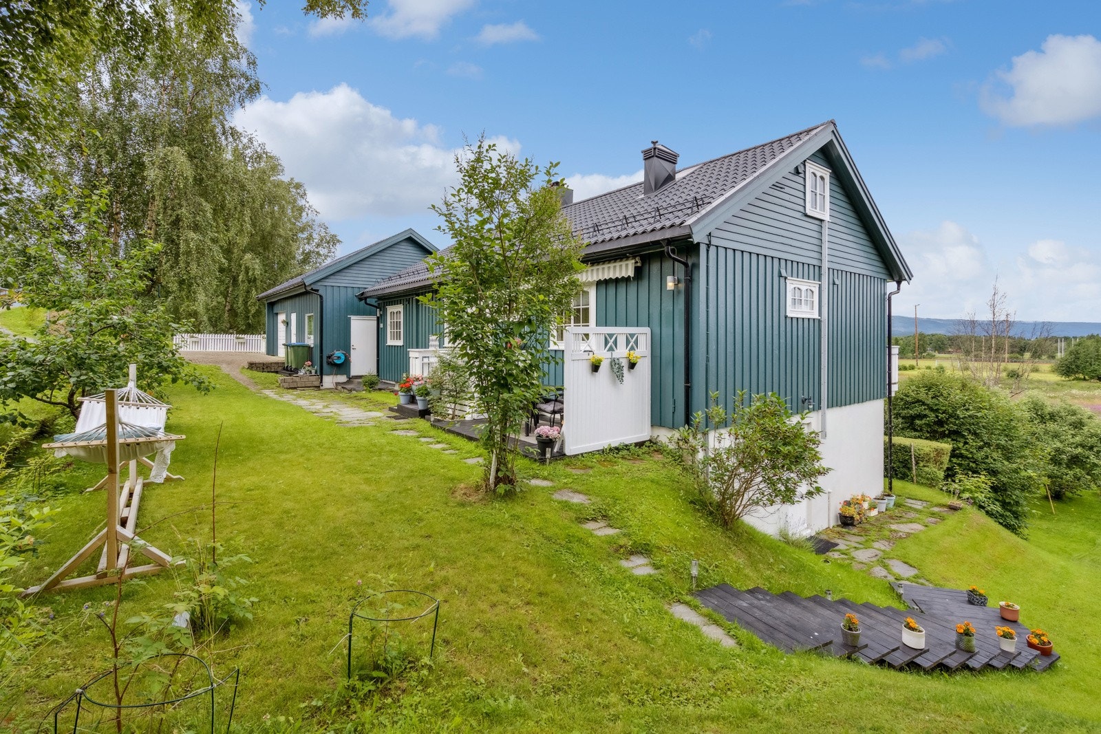 Boligen har en pent opparbeidet tomt opparbeidet med grus, steinheller, diverse beplantning, plenareal og terrasse på terreng. Galleribilde
