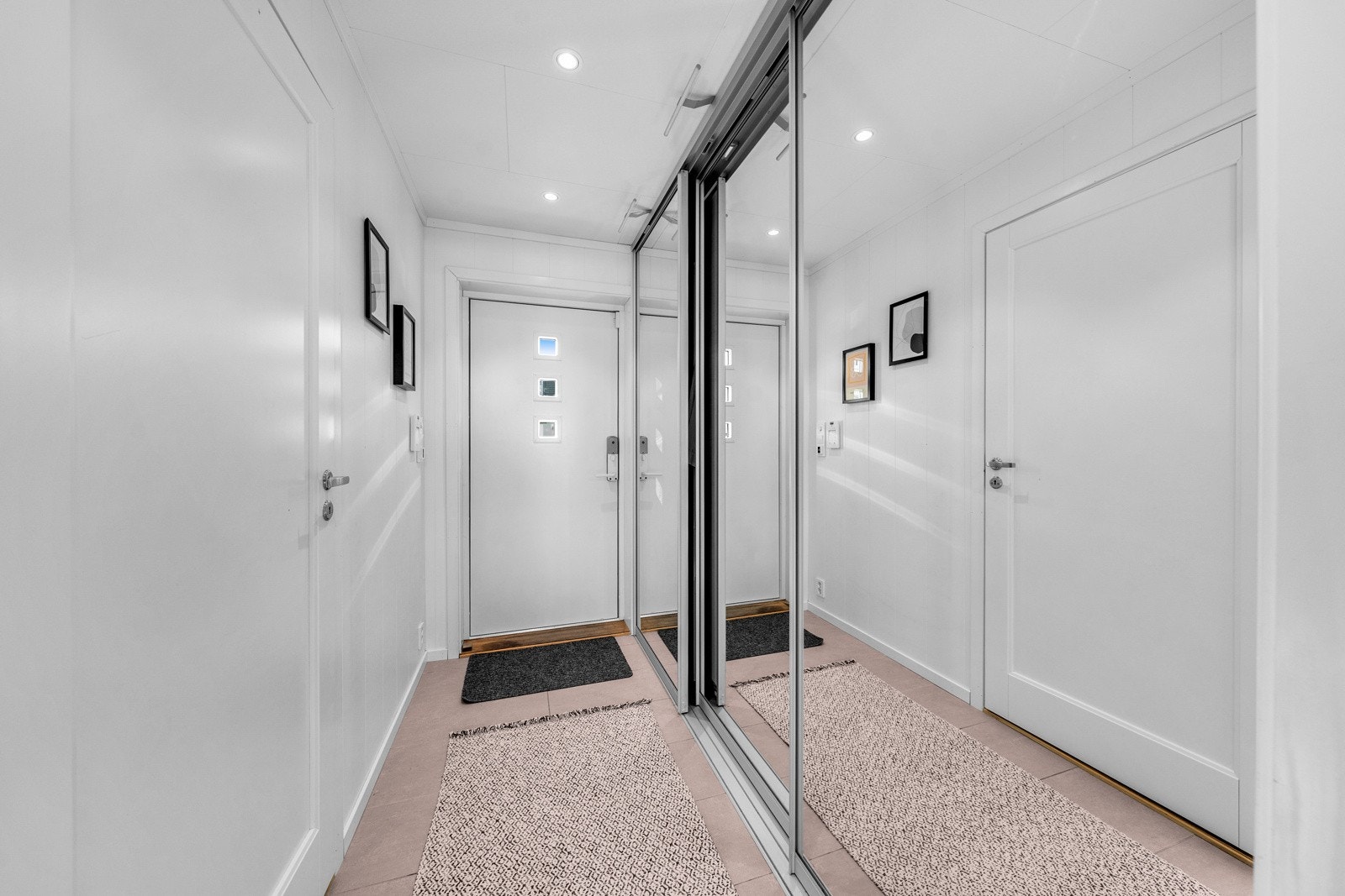 I entreen er det sandfargede gulvfliser over gulvvarme og stor skyvedørsgarderobe. Galleribilde