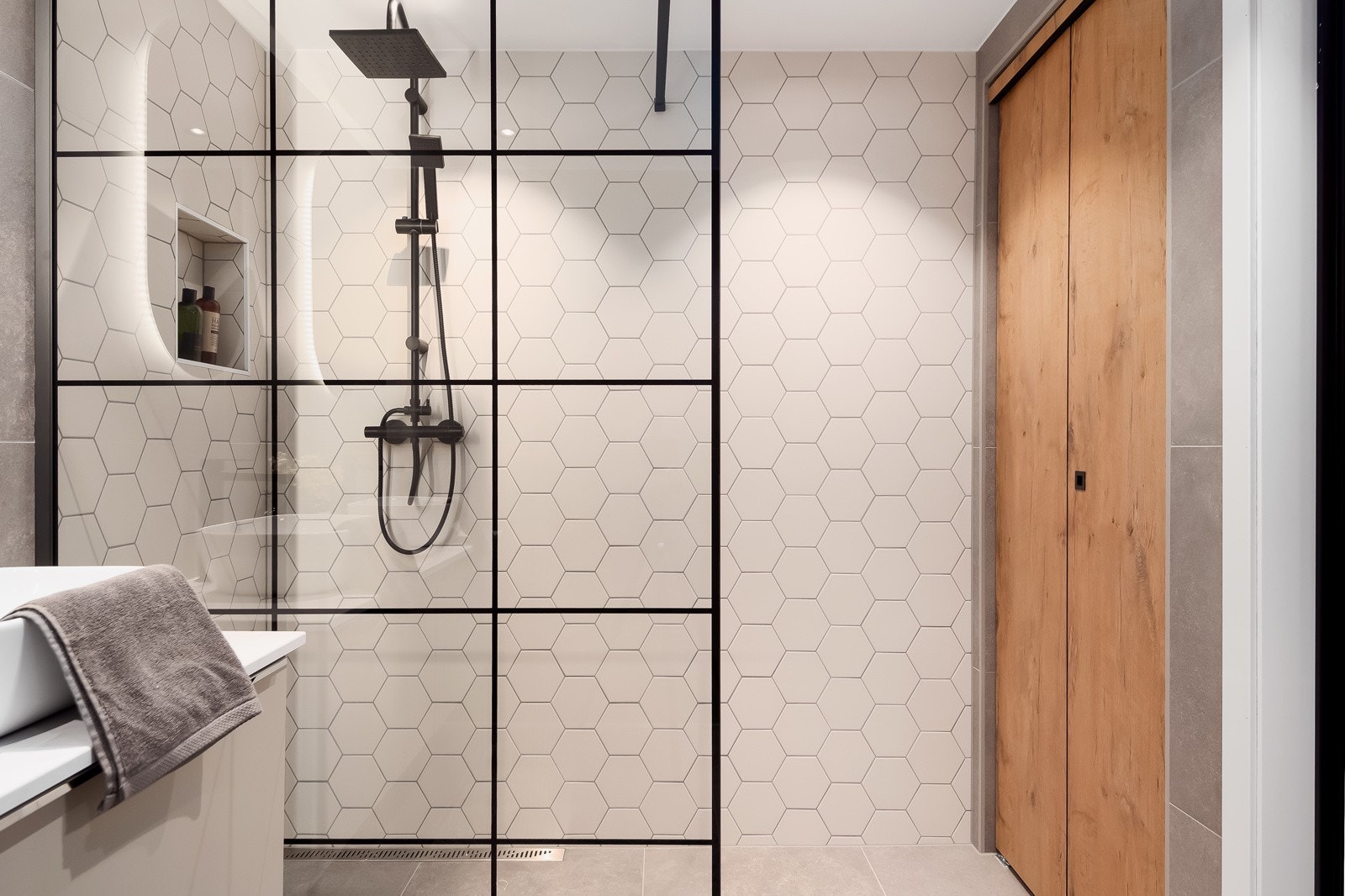 Badet er nydelig. Flisen dere her ser på veggen heter Hexagon White matt 14,2x16,4. Den spesialbestilte døren, skjuler varmtvannstanken Galleribilde