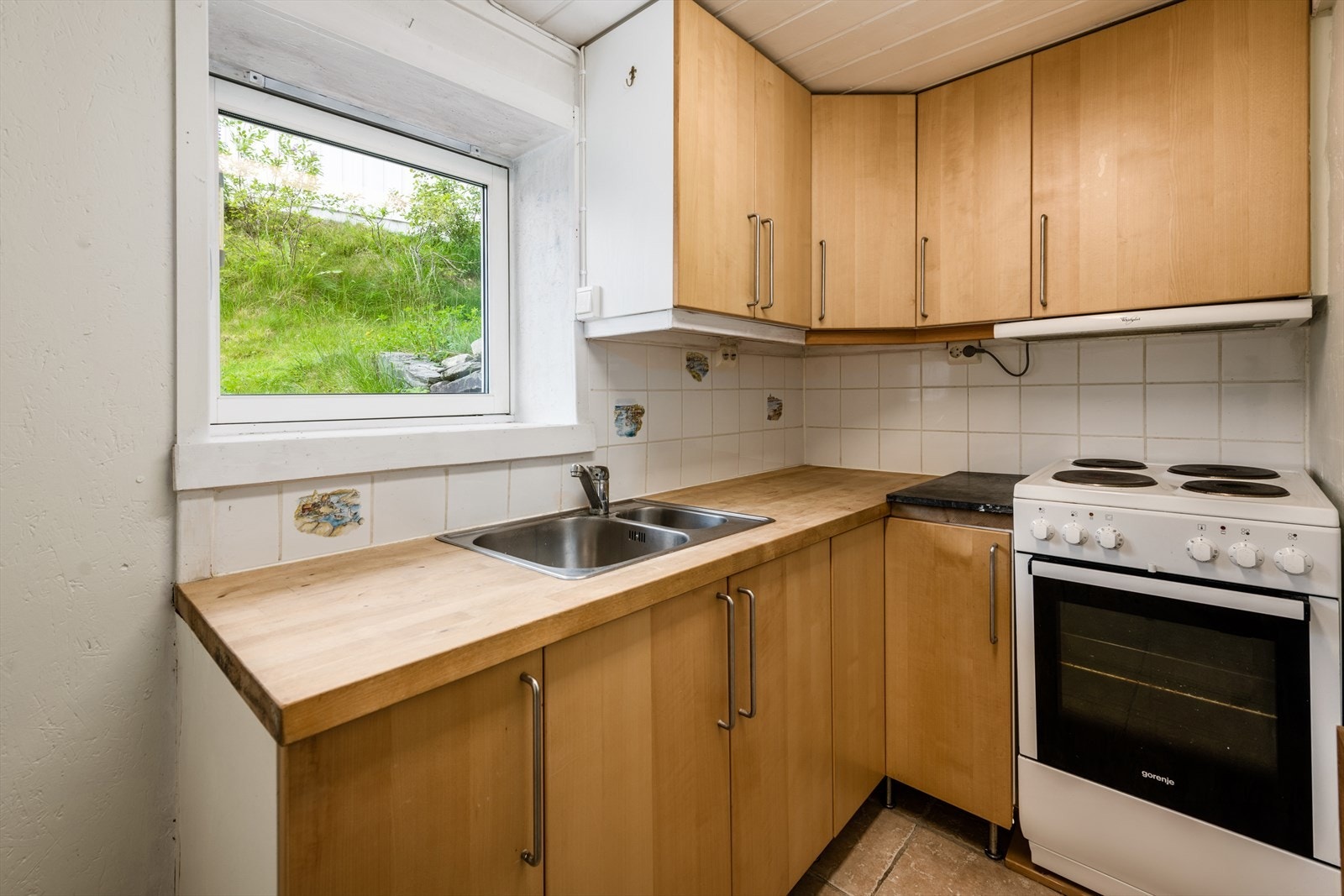 Fliser på gulv og malte murvegger. Kjøkkeninnredning fra IKEA med glatte fronter. Fliser over heltre benkeplate. Galleribilde