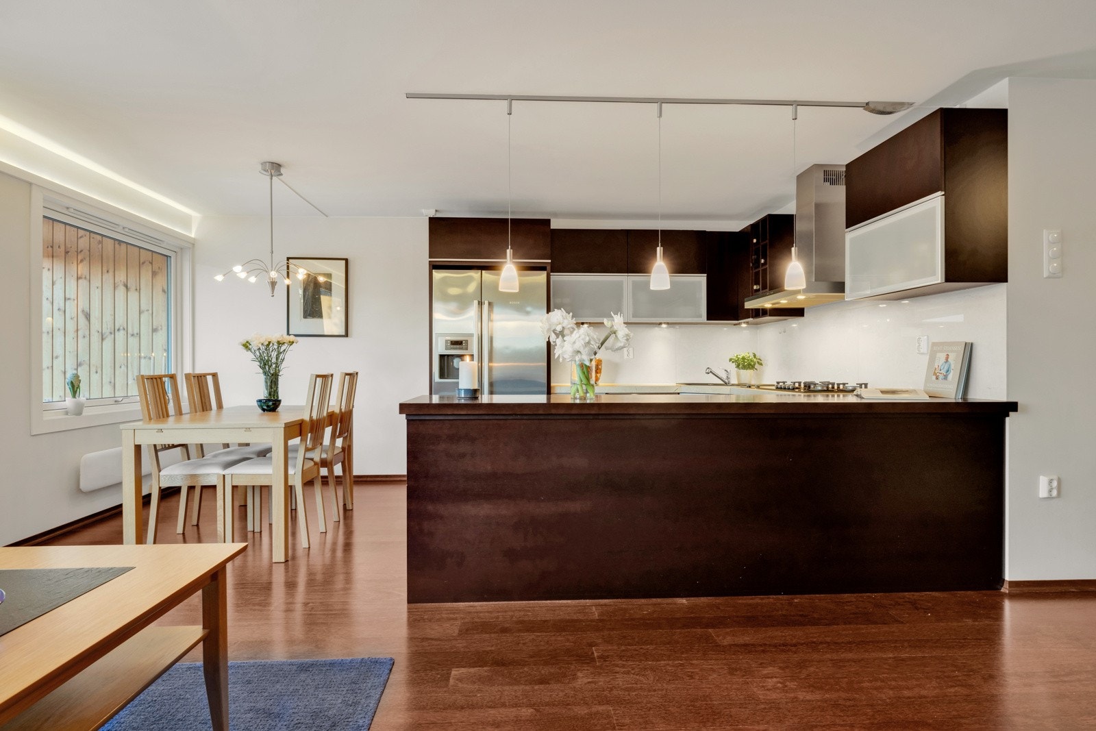 Den åpne løsningen mellom stue og kjøkken gjør rommet som et naturlig samlingssted for venner og familie. Galleribilde