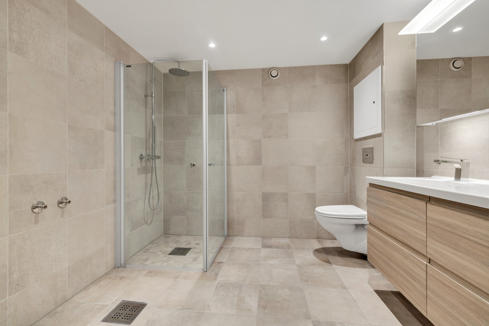 Delikat og pent flislagt bad med varme i gulv, downlights i himling og opplegg for vaskemaskin. Galleribilde