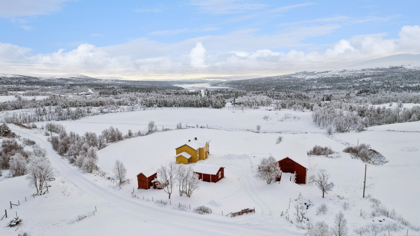 Oversiktsbilde over tunet og bygda. Langsjøen ses bak i bildet. Galleribilde