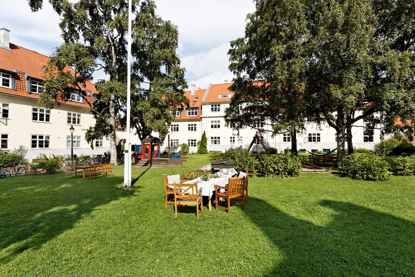 Frodig bakgård med flere sitteplasser Galleribilde