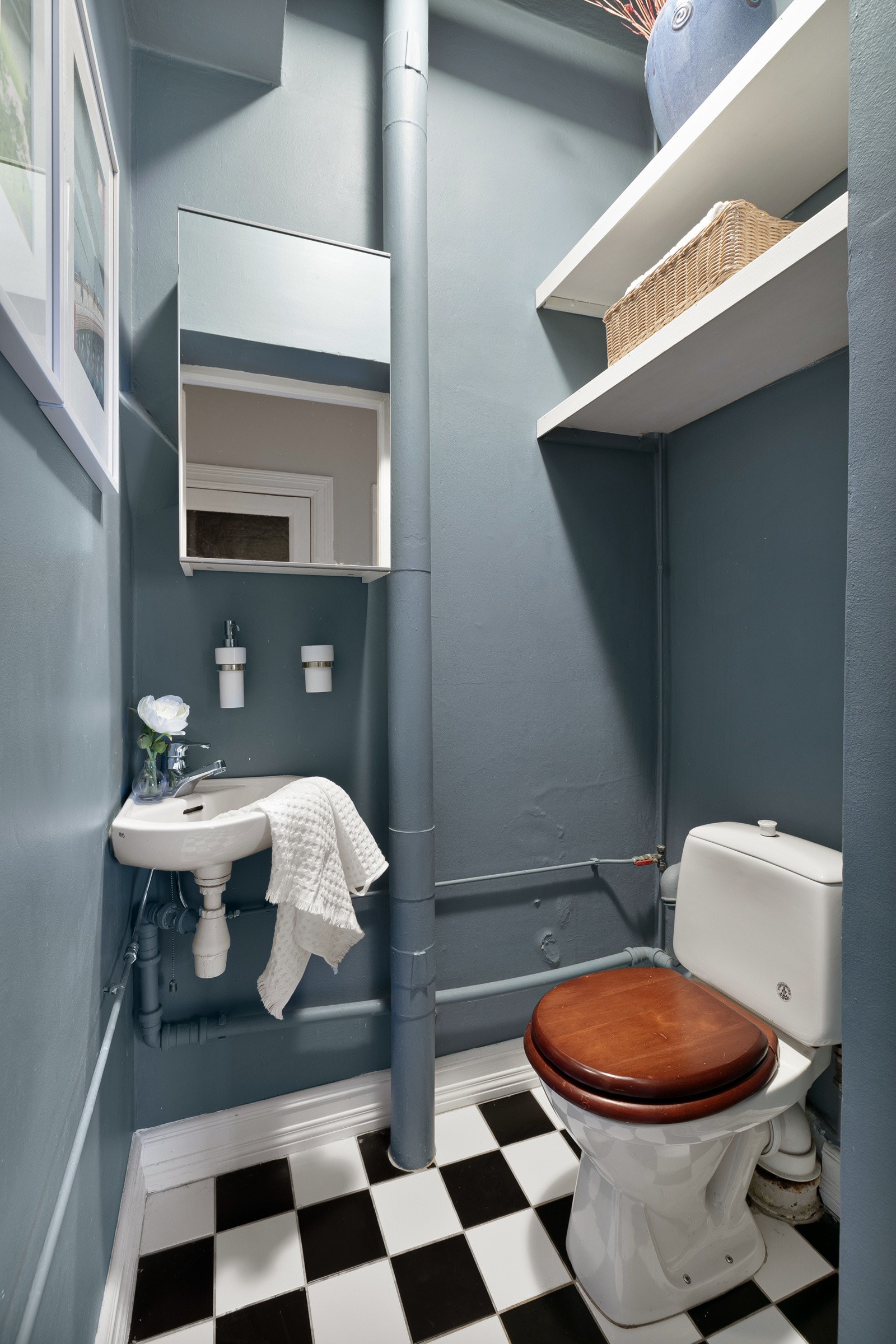 Praktisk separat toalett med flislagt gulv, glatte malte flater, servant med speilskap og klosett. Galleribilde