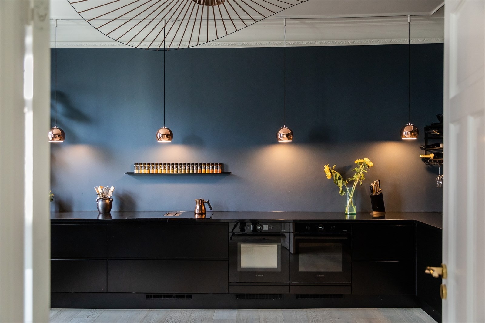 Kjøkkeninnredning består av glatte, mørke fronter, benkeplate av stein og stilrene farger. Galleribilde