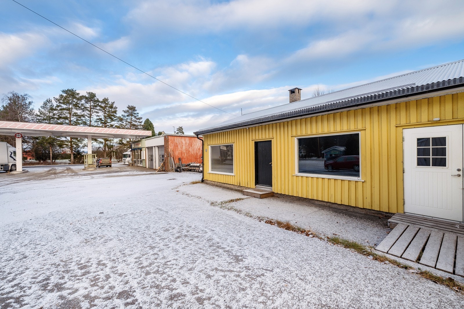 Det er parkeringsmuligheter på egen asfalterte gårdsplass foran bygget. Bygget er nabo til en eldre bensinstasjon. Galleribilde