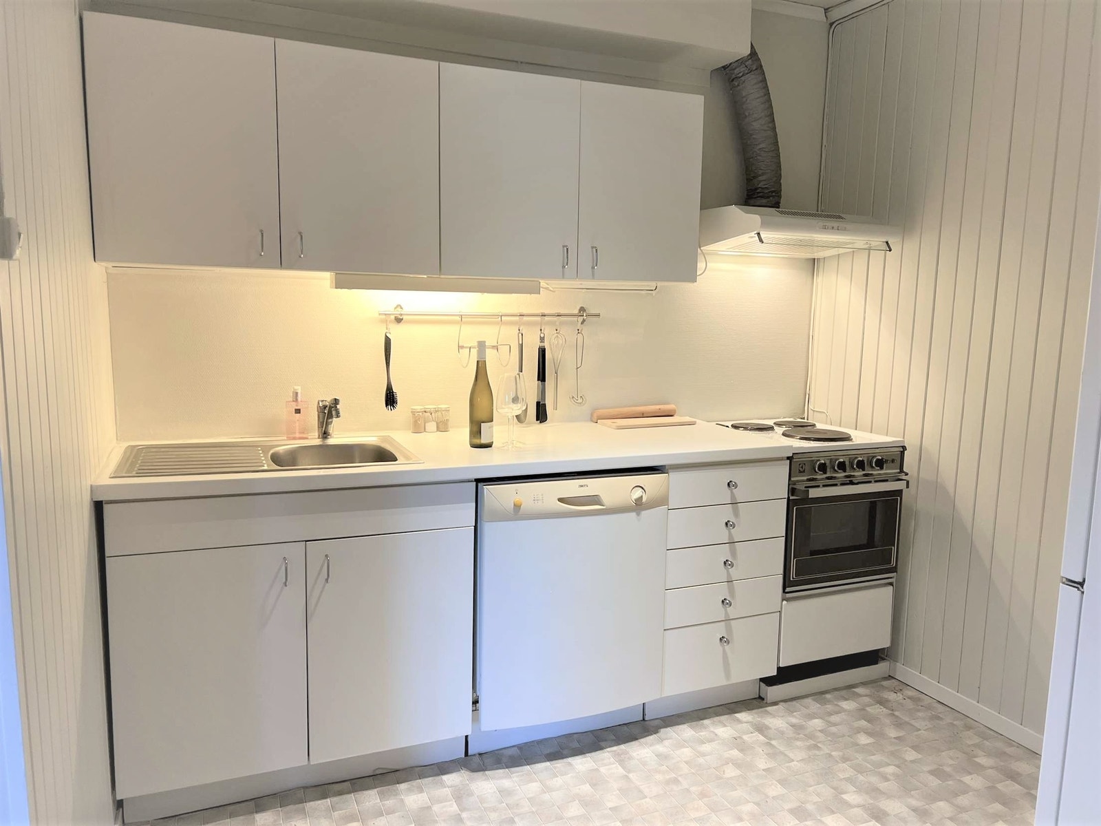 Enkelt separat kjøkken med ovn, vaskemaskin og kombiskap Galleribilde