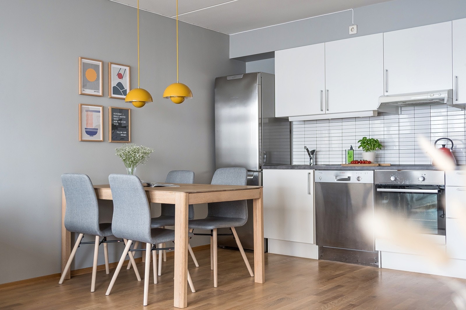 Kjøkkenet er innredet med lyse, glattfolierte fronter og laminert benkeplate. Flotte fliser på bakvegg gir et moderne preg. Galleribilde