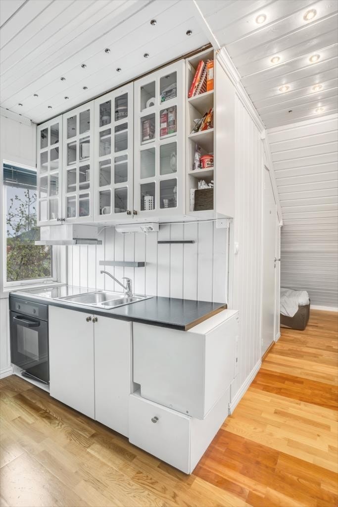 Fullt kjøkken med stekovn, platetopp, ventilator og oppvaskmaskin. Galleribilde