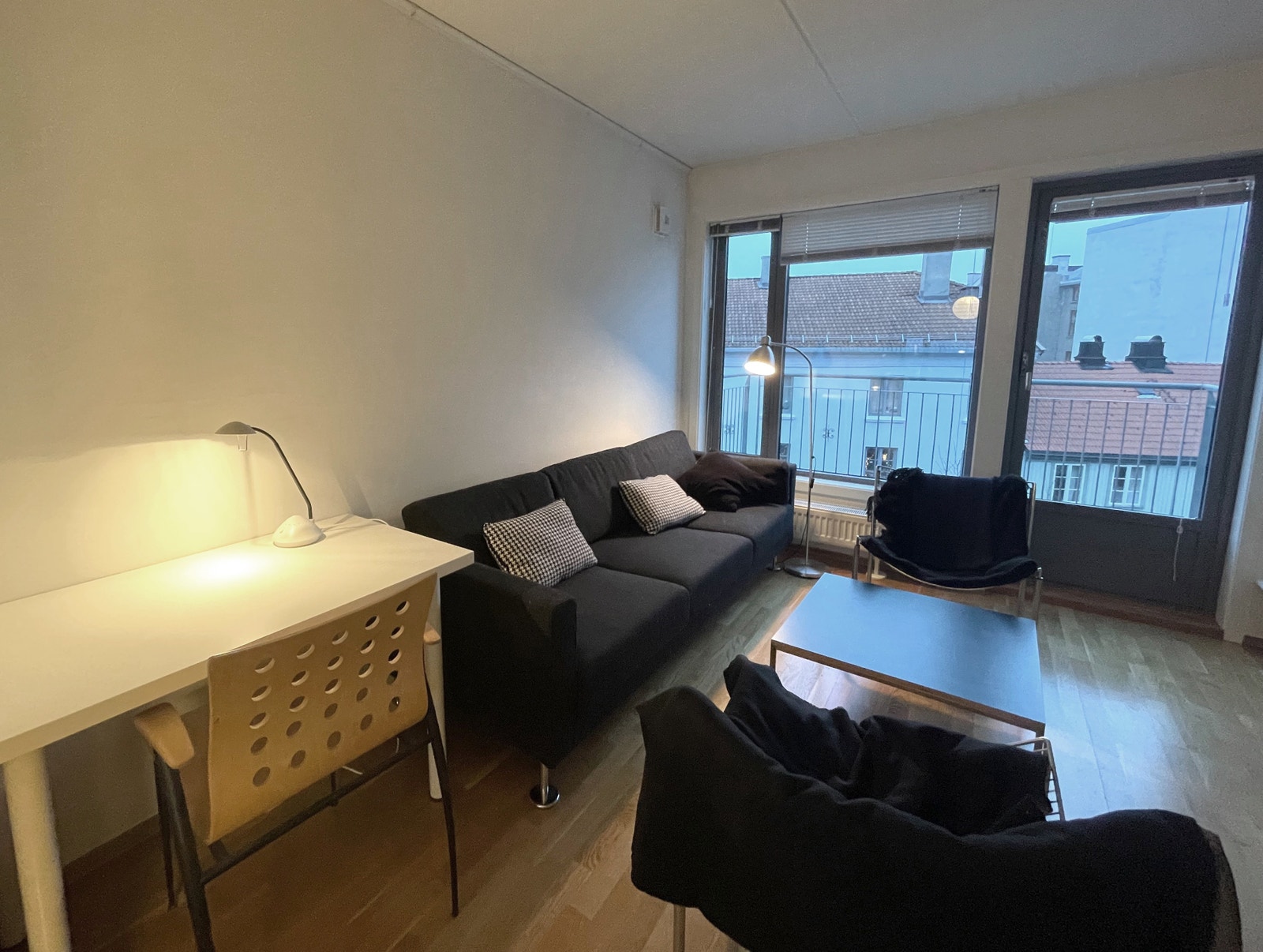 Hyggelig stue med gode lysforhold, liten arbeidsstasjon og innebygde bokhyller. Galleribilde