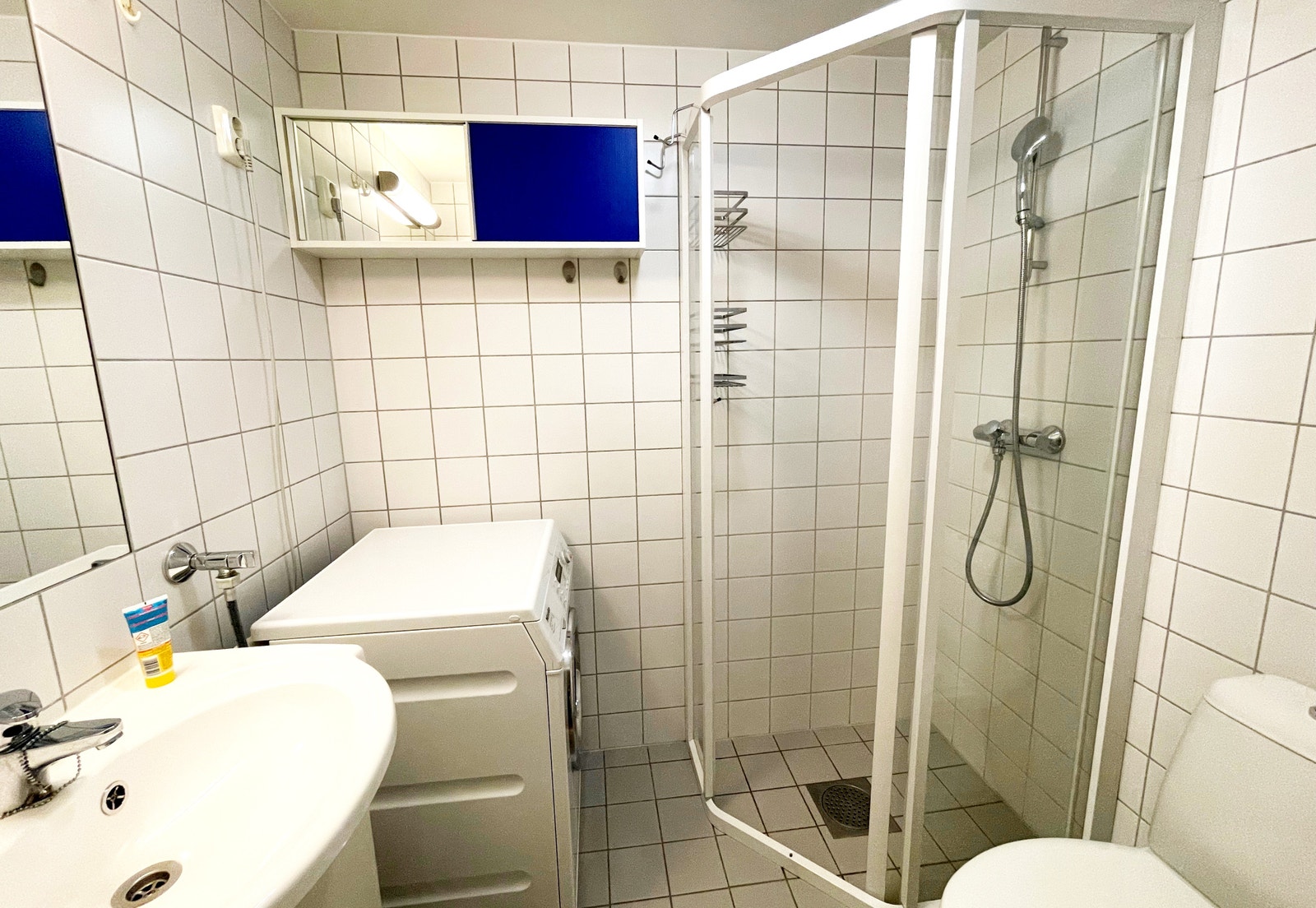 Bad med dusjhjørne og Miele vaskemaskin Galleribilde