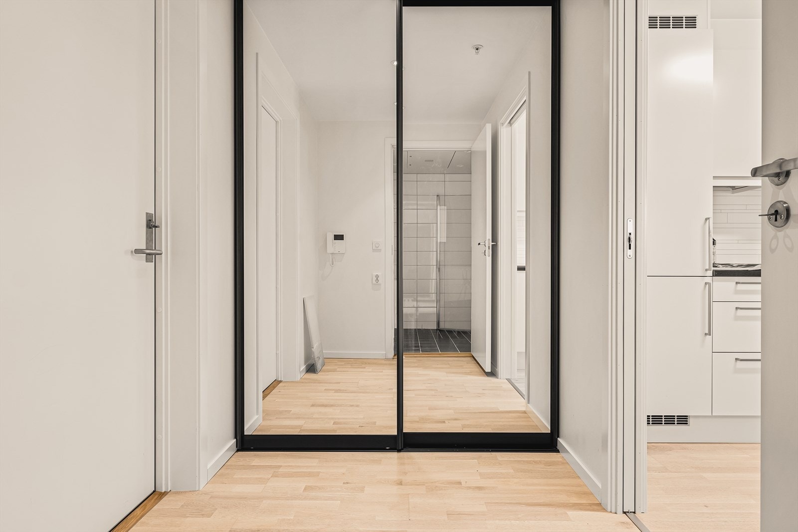 Romslig gang med parkett gulv, downlights, skyvedørsgarderobe med speilfronter - god plass til oppheng av yttertøy og plassering av sko. Galleribilde