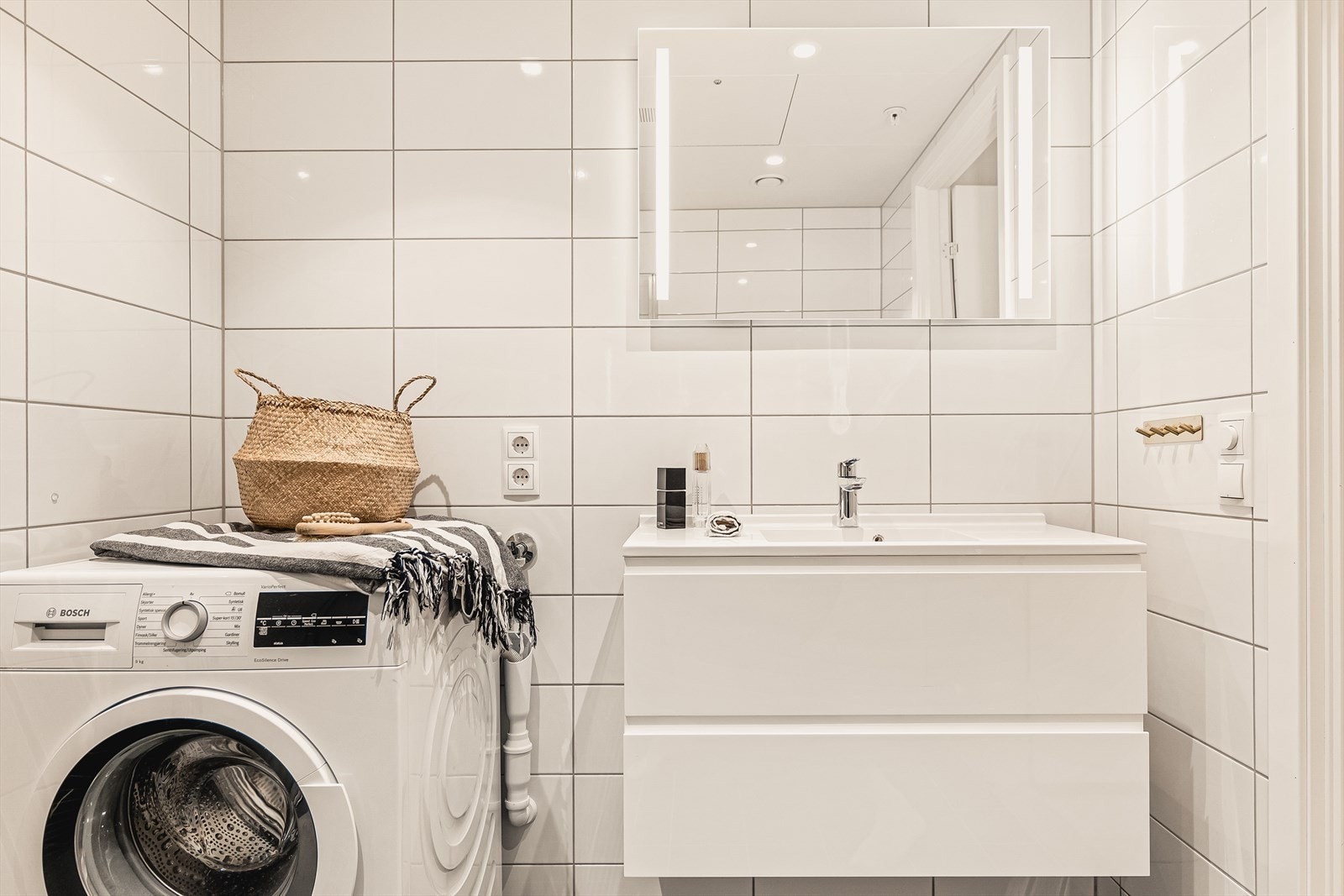 Baderommet er innredet med innfelte lys i speil, veggheng toalett, downlights, heldekkende servant med skuffer og vaskemaskin + tørketrommel. Galleribilde