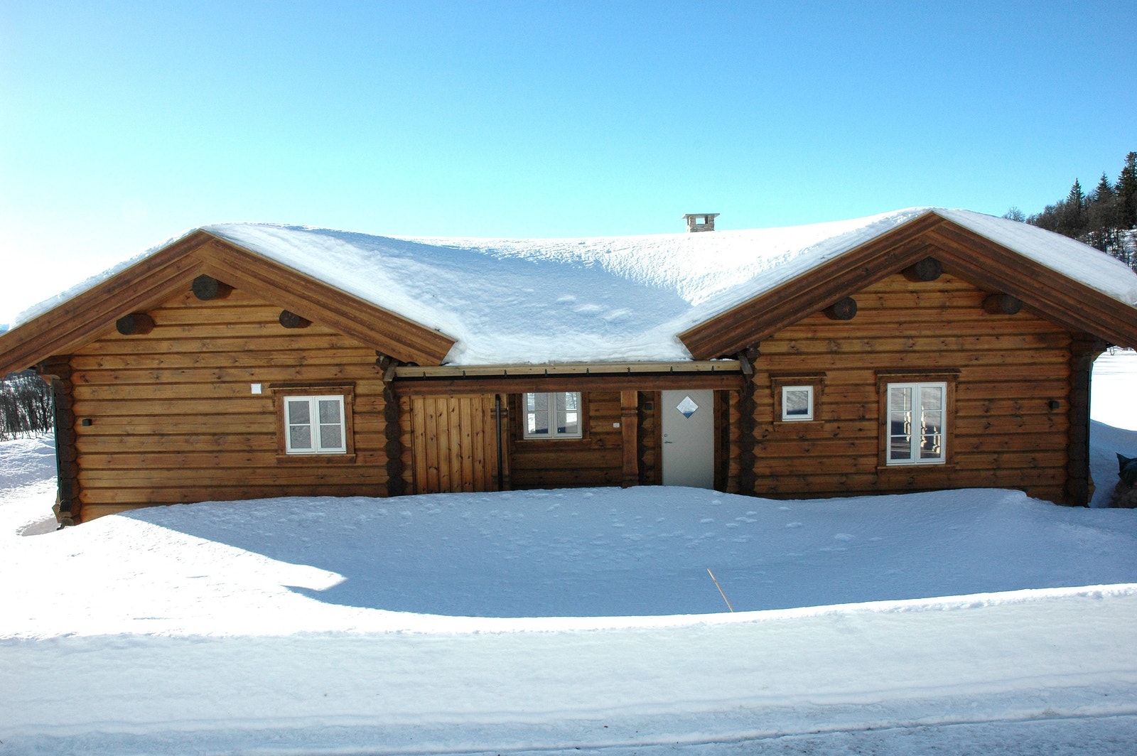 Klassisk H-hytte. Utvendig beiset i Møretyri Tømmerolje. Opparbeidet parkeringsareal på kort og langsiden av hytta. Galleribilde