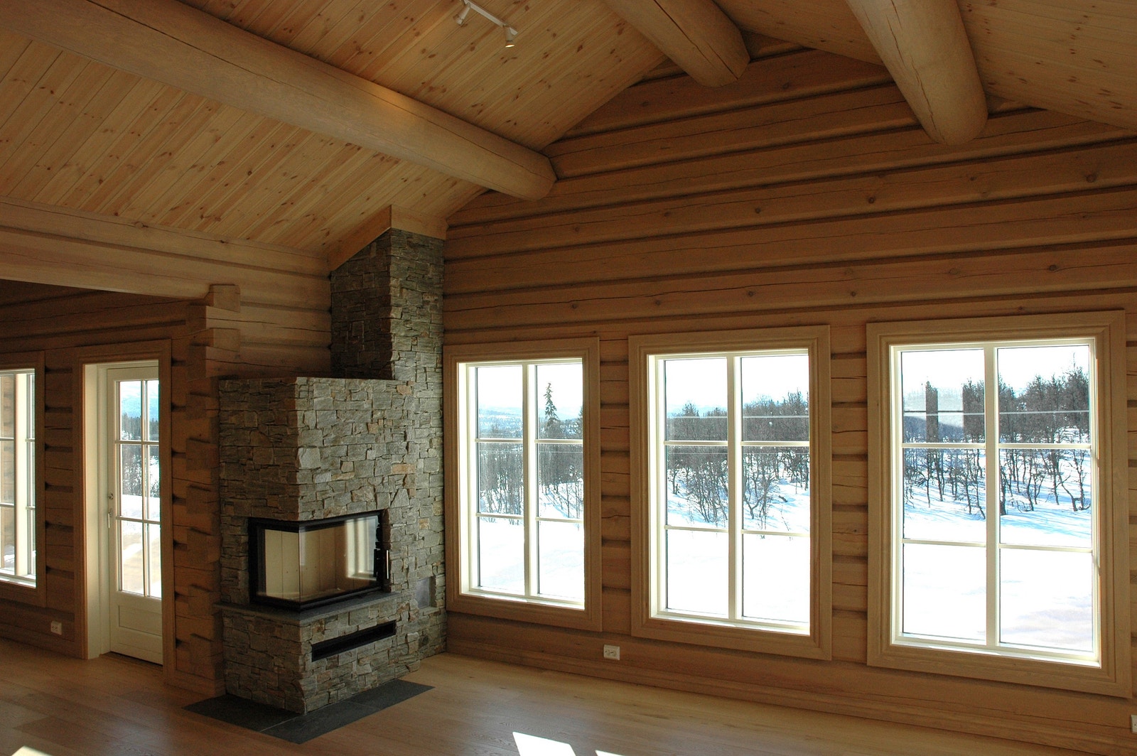 Vindusrekke mot sørvest gir flott utsikt fra stua. Flott peisinnsats fra Seljord Varme i Valdres naturstein, god takhøyde, massive takåser og interiørbeiset tømmervegger skaper en herlig atmosfære. Galleribilde