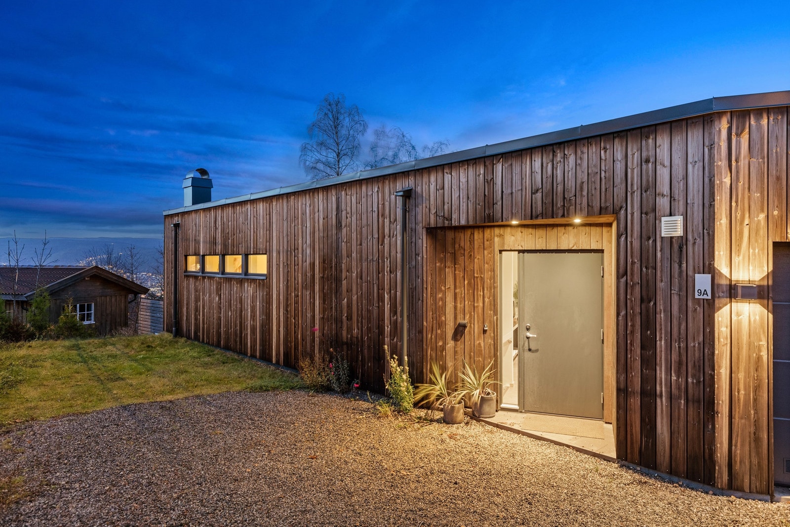 Integrert dobbelgarasje med el-billading og gruset gårdsplass Galleribilde